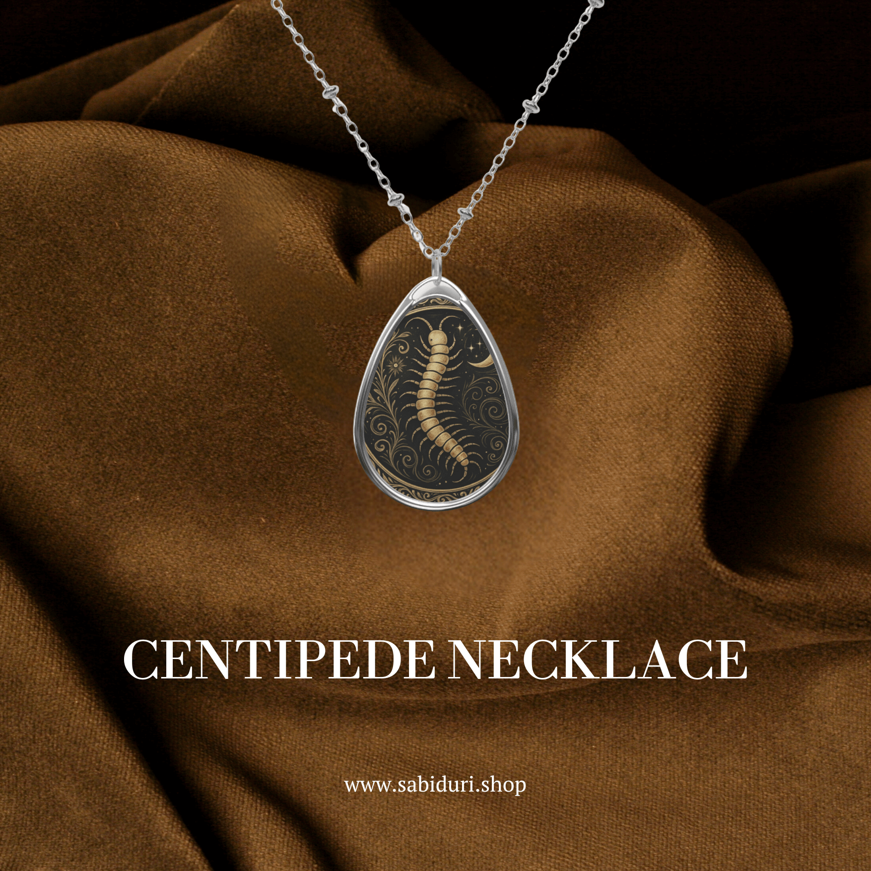 Centipede necklace with ornate golden detailing showcased against rich brown fabric, with the text “CENTIPEDE NECKLACE” and the shop link www.sabiduri.shop.