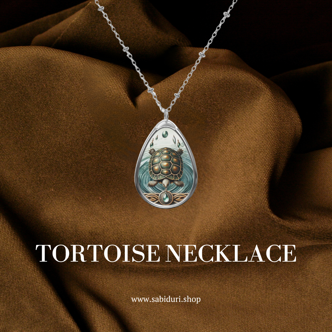 A tortoise spirit animal necklace, set against a rich brown fabric background. The text "TORTOISE NECKLACE" is displayed at the bottom, along with the website link "www.sabiduri.shop".