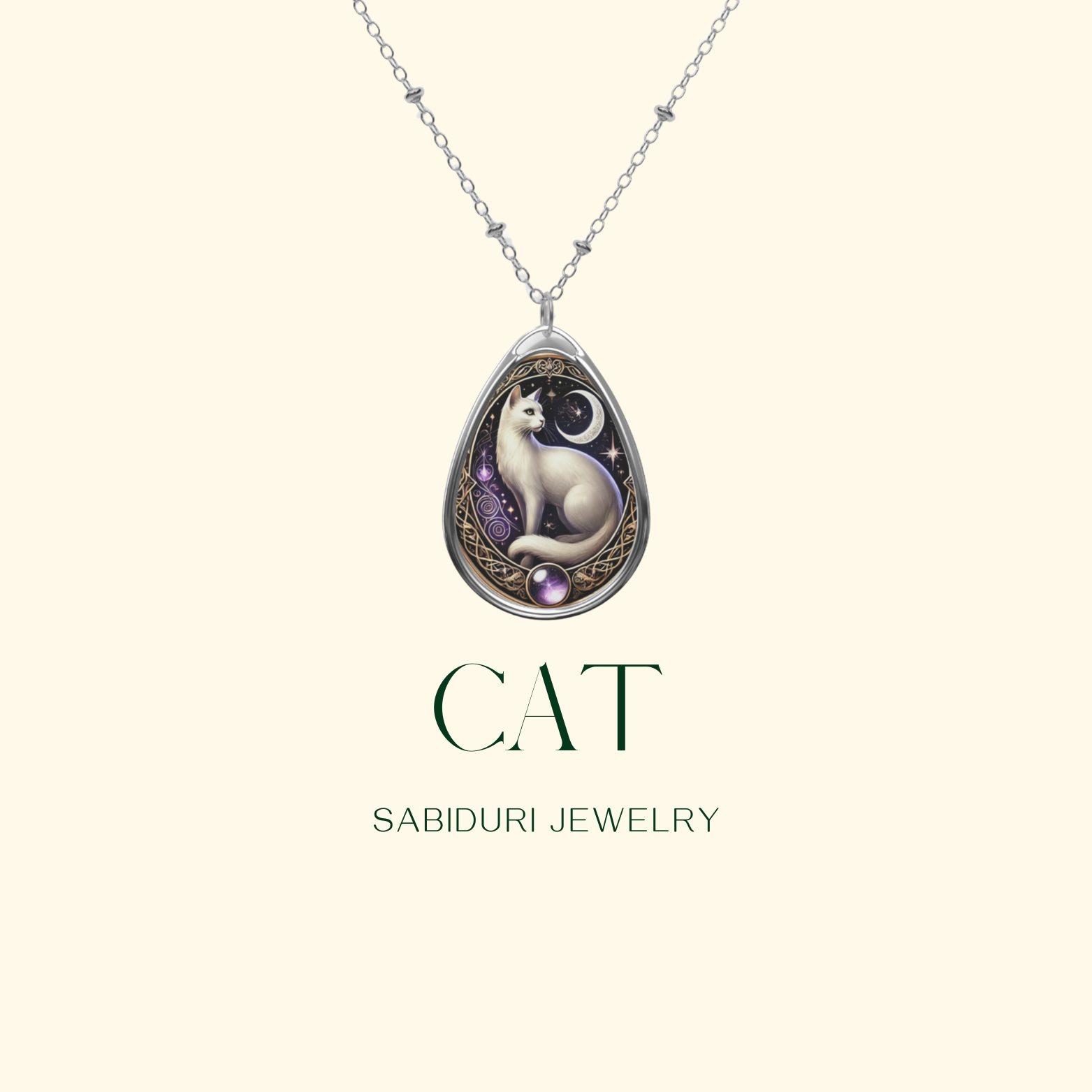A close-up of a teardrop pendant featuring a celestial white cat against a starry night sky, framed with golden swirls and purple gemstone accents. The words "CAT" and "SABIDURI JEWELRY" are written in a sophisticated serif font.