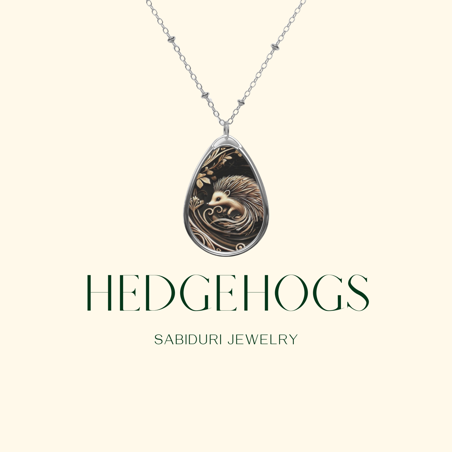 A close-up of a teardrop-shaped necklace pendant featuring a detailed design of a hedgehog surrounded by intricate, swirling patterns and leaves. Below the pendant, the text reads "Hedgehogs" and "SABIDURI JEWELRY" in elegant green font on a light background.