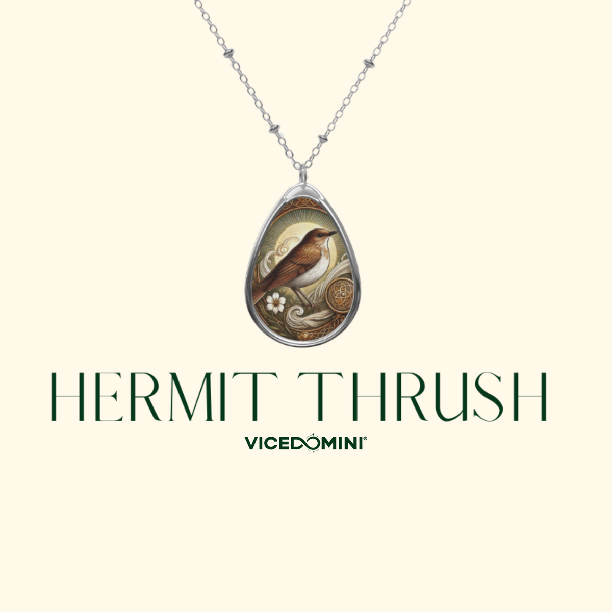 A teardrop-shaped pendant necklace featuring an illustration of a hermit thrush bird, displayed on a silver chain against a light cream background. Below the necklace, the text 'HERMIT THRUSH' and brand 'VICEDOMINI' are printed in dark green.