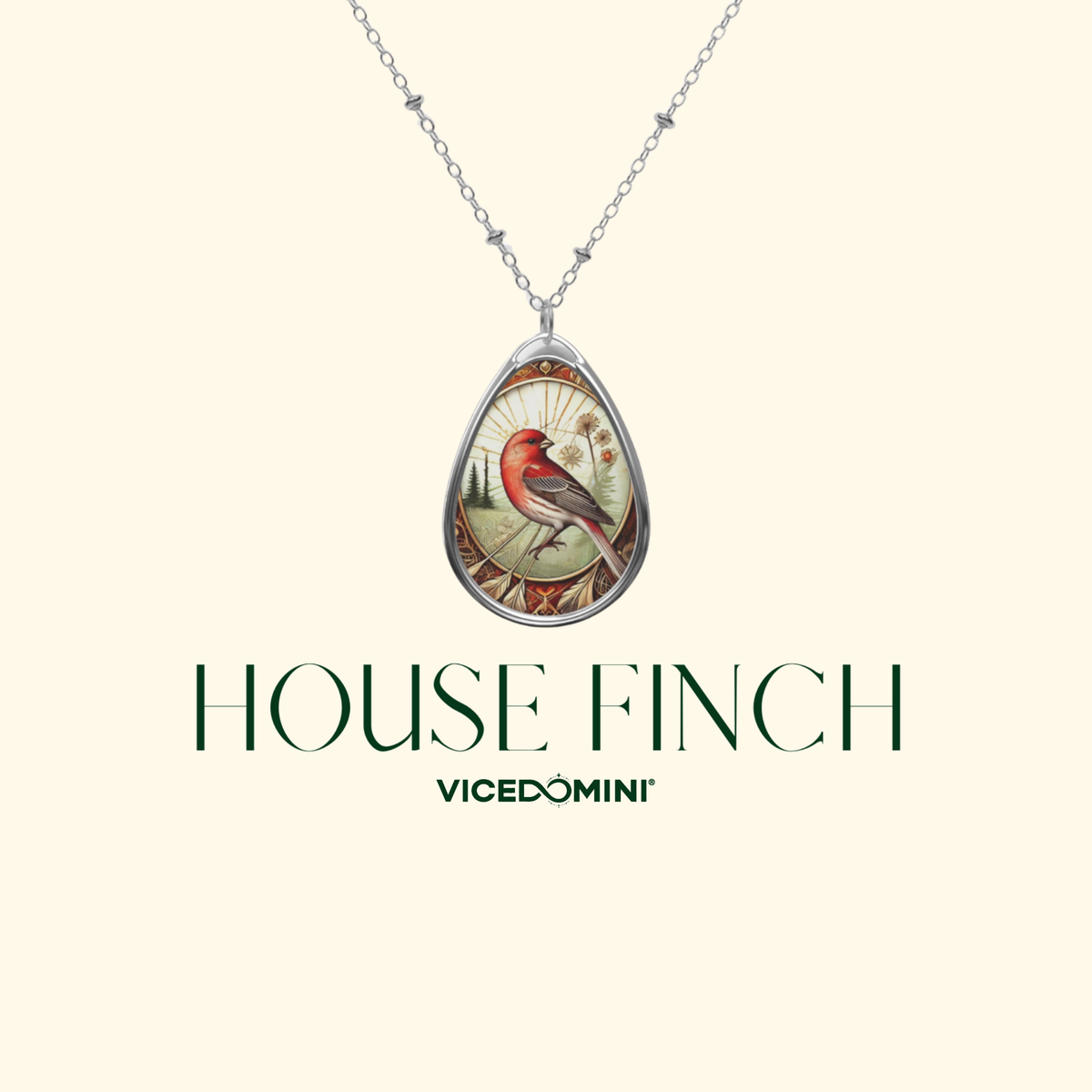 A silver teardrop pendant necklace featuring an illustrated red house finch on a cream background, with the text 'HOUSE FINCH' and 'VICEDOMINI' below on a light cream backdrop.