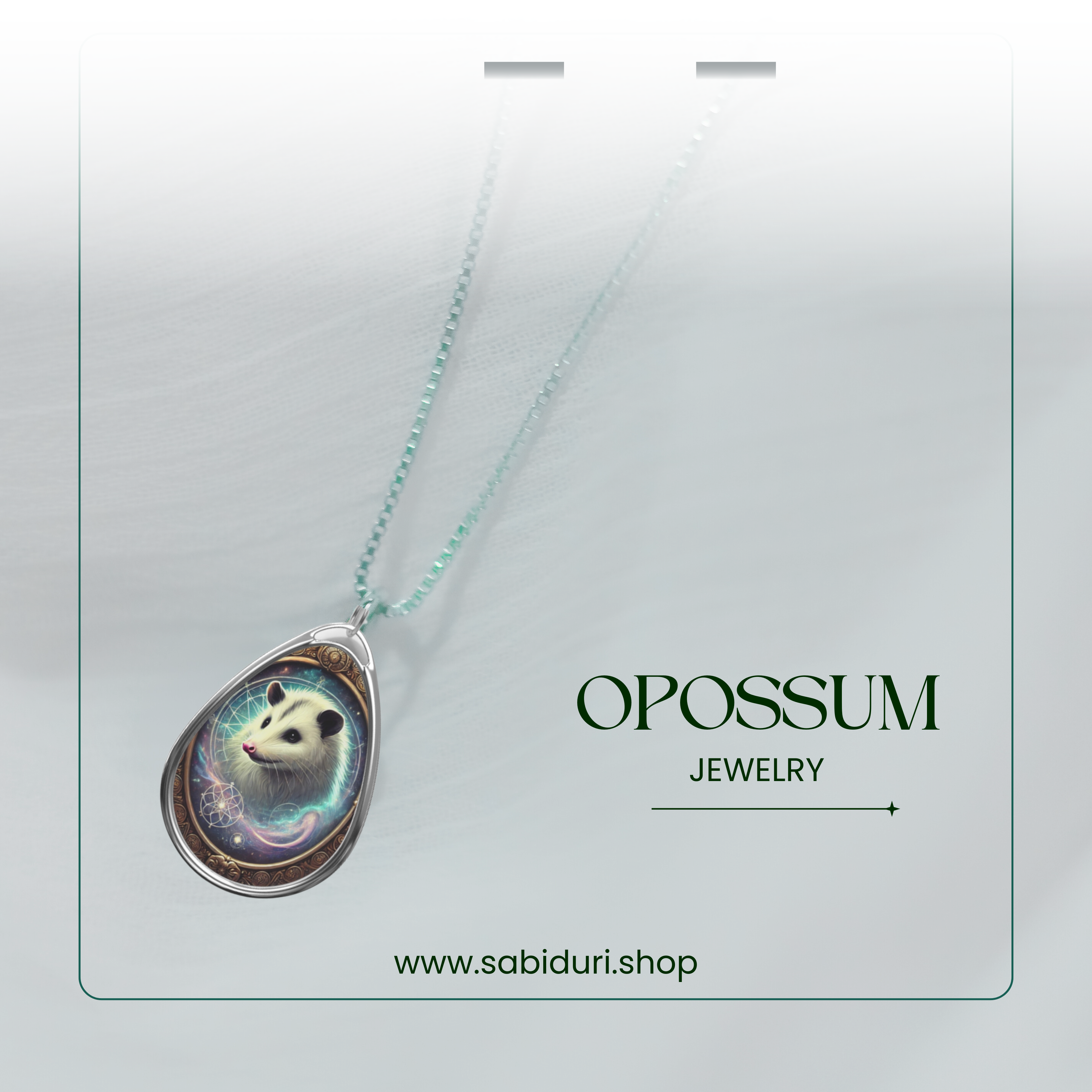 A close-up of the opossum pendant necklace, suspended from a shimmering chain with subtle green accents. The pendant showcases a cosmic-themed opossum design framed with intricate golden swirls. The text "OPOSSUM JEWELRY www.sabiduri.shop" is neatly displayed in the lower section of the image.