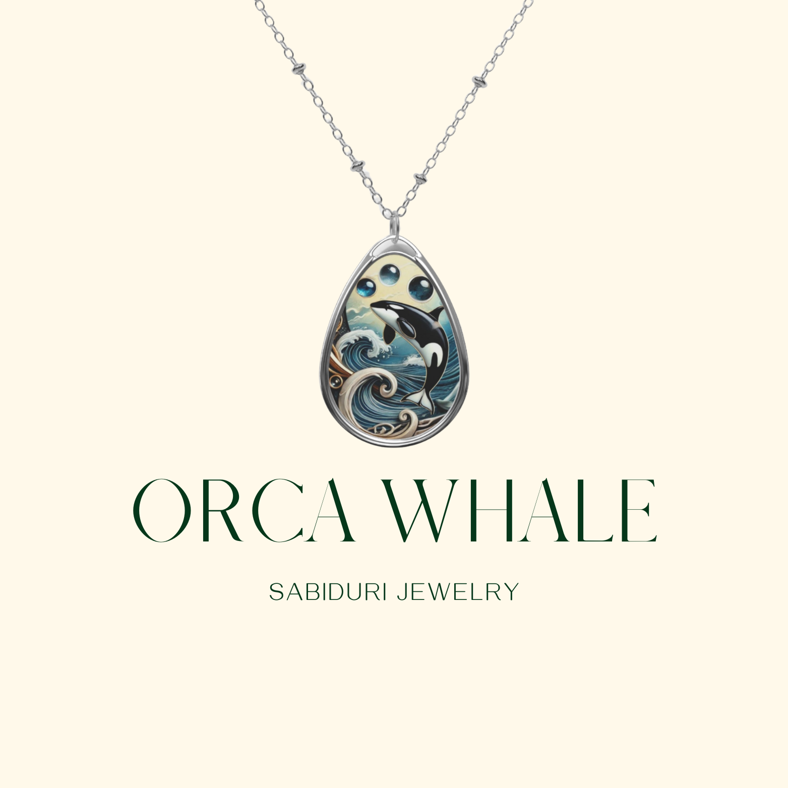 A teardrop-shaped pendant featuring an orca whale design surrounded by waves and sky elements, with three small blue gemstones above the orca. Below the pendant, the text reads "ORCA WHALE" in large letters and "SABIDURI JEWELRY" in smaller letters.