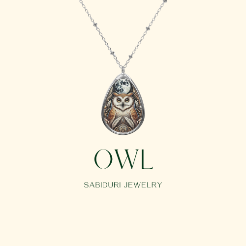 A close-up of a silver owl pendant necklace suspended on a minimalist cream-colored background. The owl design is detailed, with the moon and intricate patterns surrounding it. The text reads, "OWL Sabiduri Jewelry."