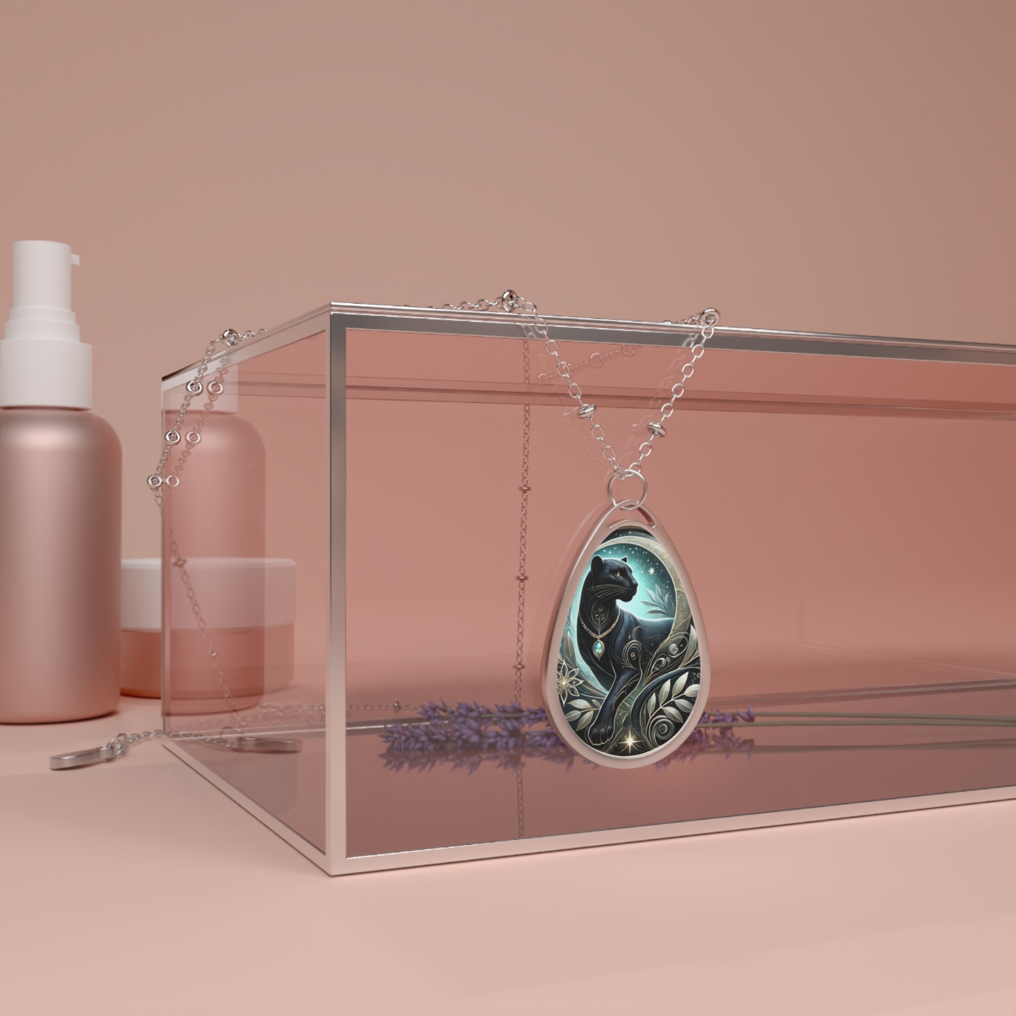 A silver necklace with a teardrop-shaped pendant featuring an artistic illustration of a black panther surrounded by celestial patterns and nature-inspired details, displayed elegantly on a pink backdrop.