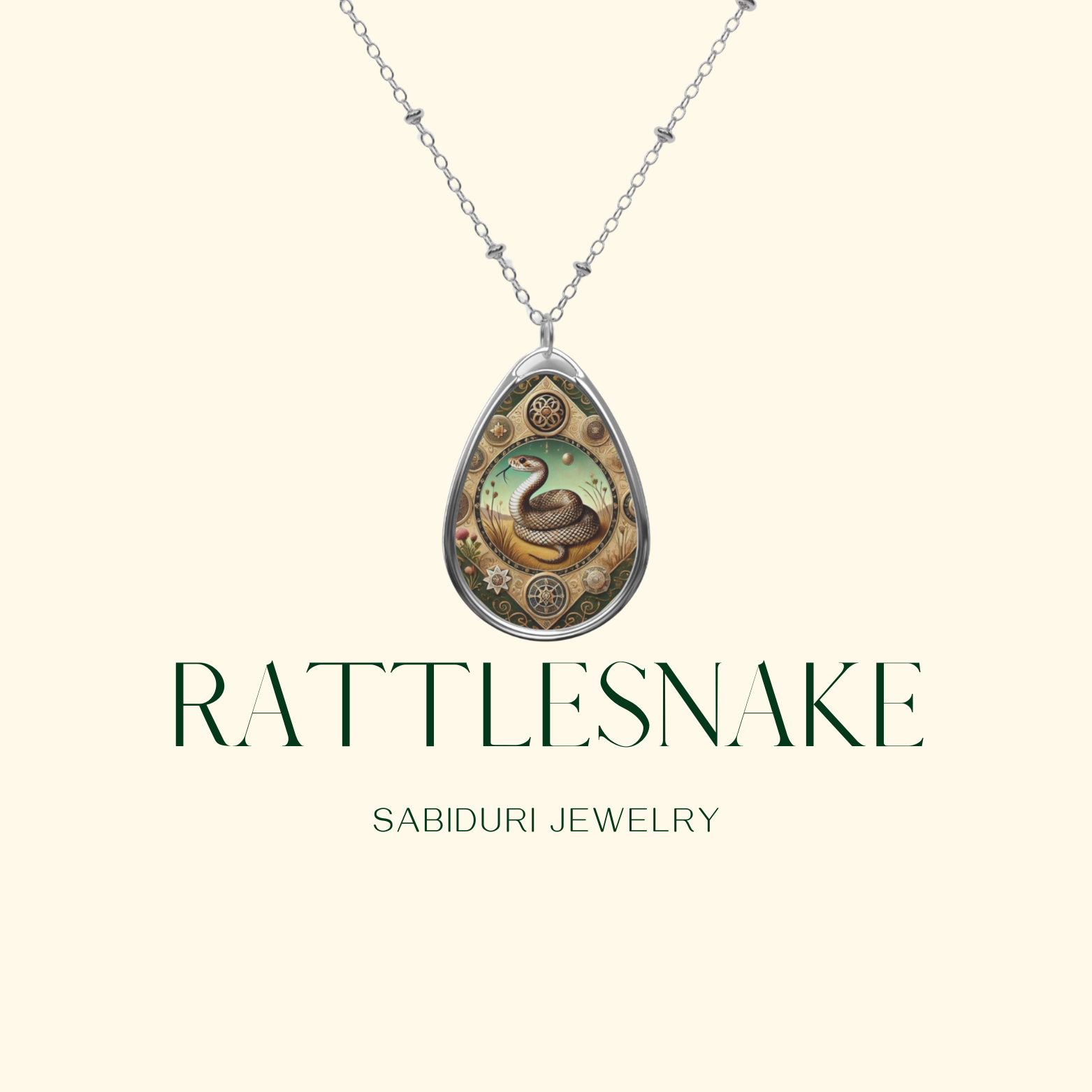 A minimalist image showcasing a teardrop-shaped pendant with a coiled rattlesnake design, surrounded by gears and flowers on a green and gold background. The pendant hangs from a delicate silver chain with the text "Rattlesnake" and "Sabiduri Jewelry" displayed beneath it.
