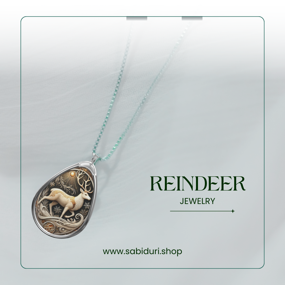A reindeer pendant necklace displayed on a soft white background. The pendant shows an elegant reindeer with intricate antlers and delicate wintry designs, surrounded by a detailed frame. The text reads "REINDEER Jewelry" and includes the website "www.sabiduri.shop.