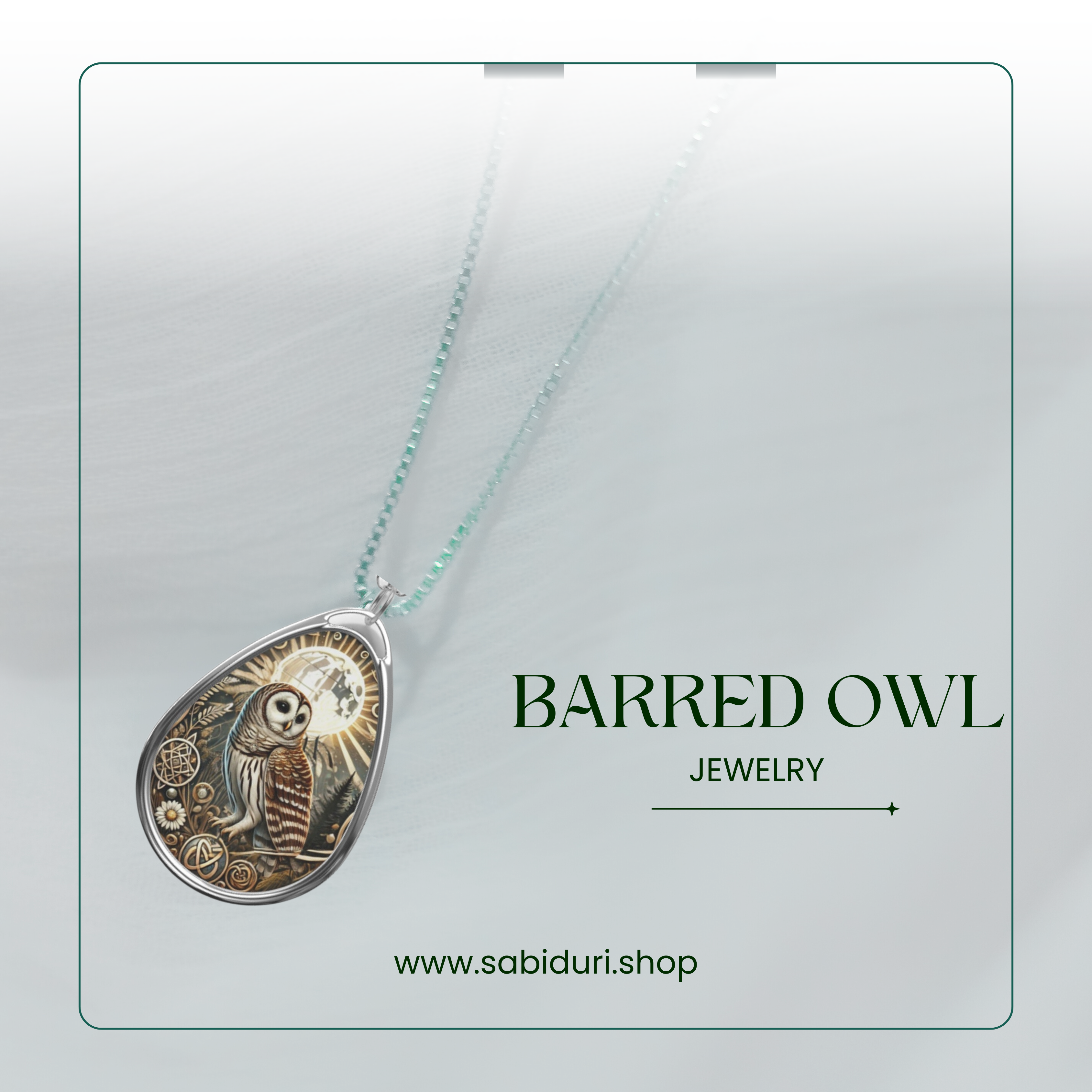 A close-up of a Barred Owl pendant necklace against a light, airy background. The pendant is teardrop-shaped, featuring a detailed illustration of an owl under a sunburst, with the text "BARRED OWL JEWELRY" and the website "www.sabiduri.shop" displayed alongside it.