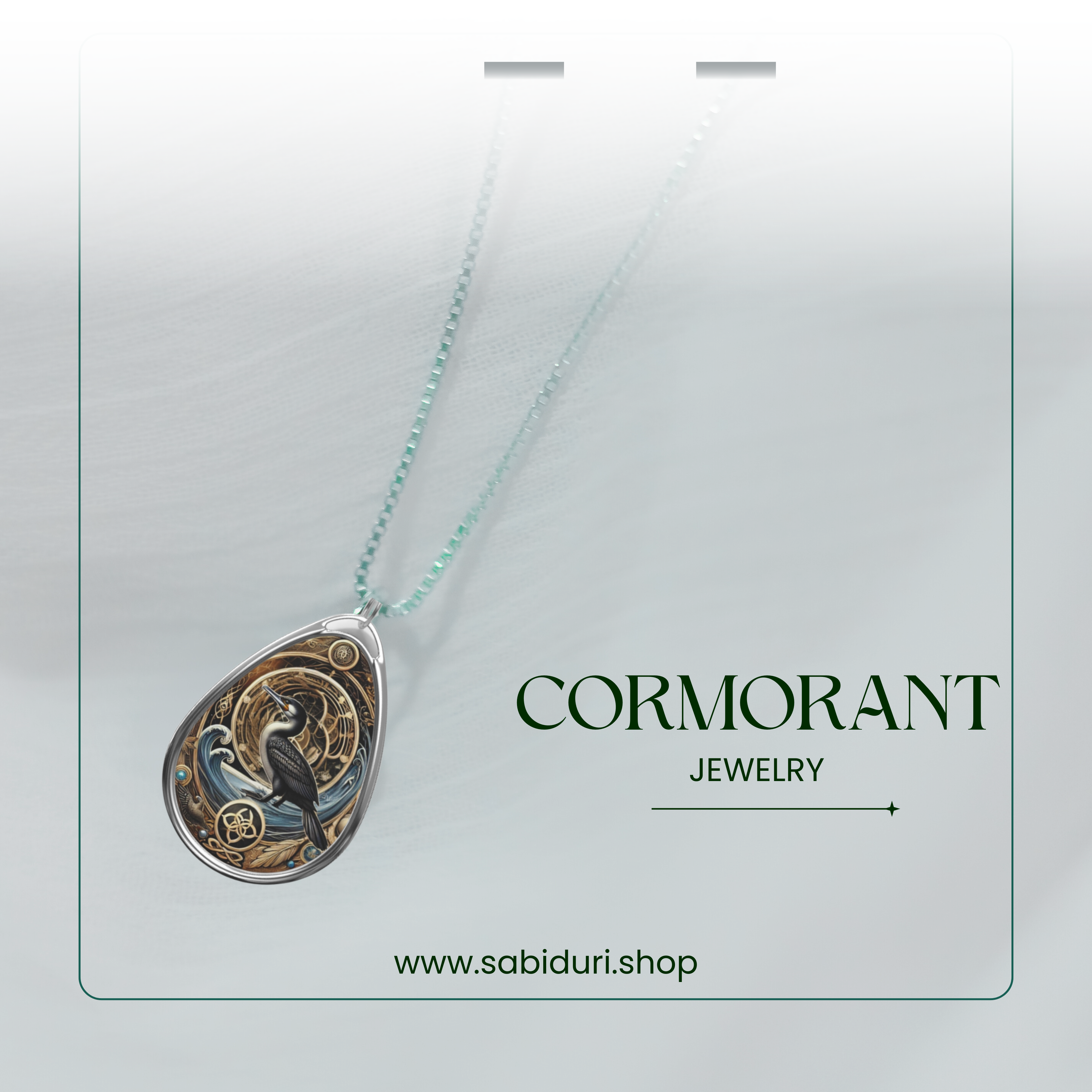A stylish product showcase of the cormorant necklace against a semi-transparent white backdrop. The pendant, featuring a black cormorant with gold and blue accents, hangs from a delicate silver chain. The text "CORMORANT JEWELRY" and "www.sabiduri.shop" is positioned to highlight the brand.
