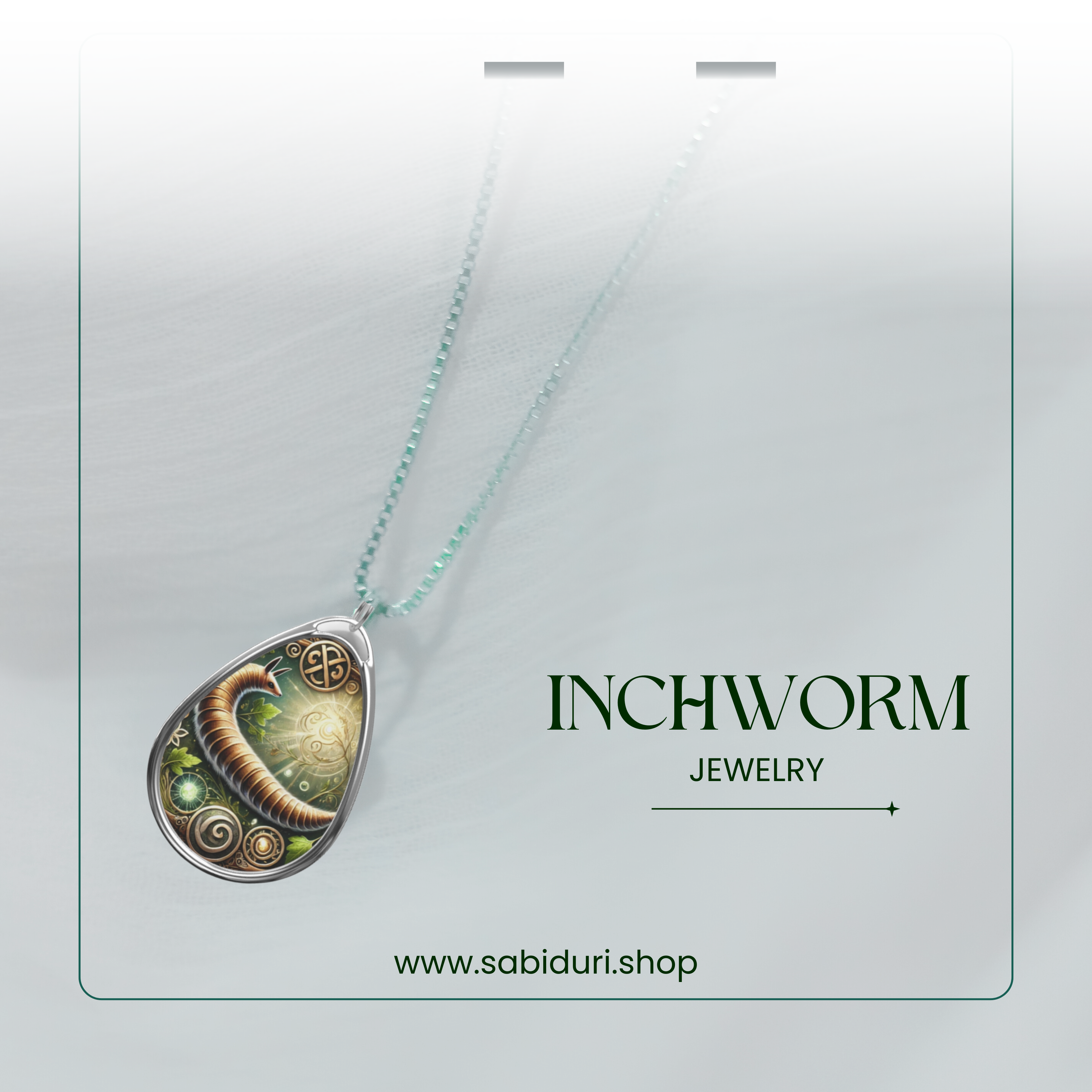 An elegant Inchworm necklace displayed against a soft white gradient background, suspended by a delicate green-beaded chain. The teardrop pendant showcases a beautifully designed inchworm motif with intricate gold filigree and glowing green embellishments. Below, "INCHWORM JEWELRY" is highlighted along with the website "www.sabiduri.shop."