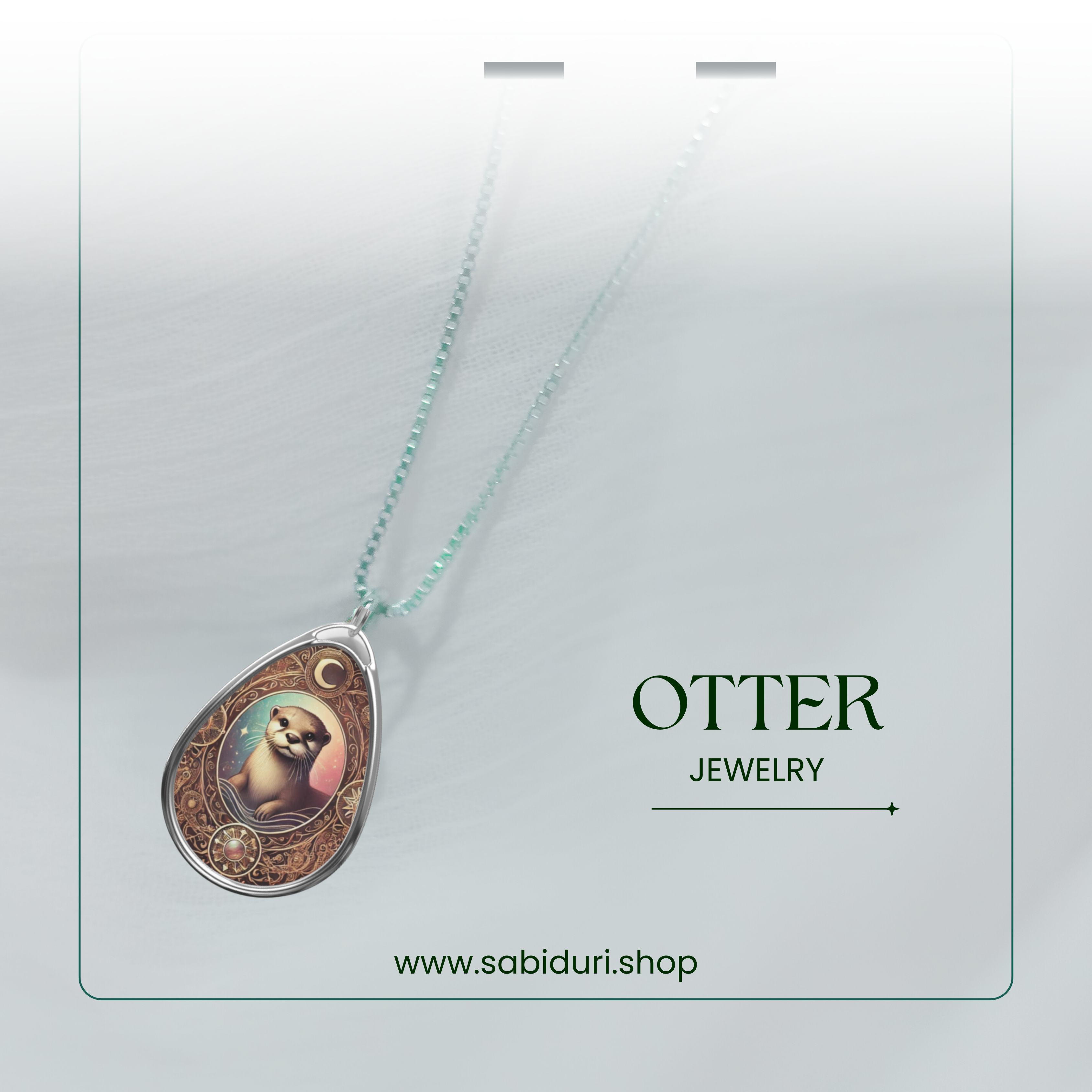 A promotional image displaying the Otter necklace on a fine, light blue beaded chain. The pendant is adorned with intricate engravings and warm-toned colors, set against a soft white background. The text includes "OTTER JEWELRY" and "www.sabiduri.shop."