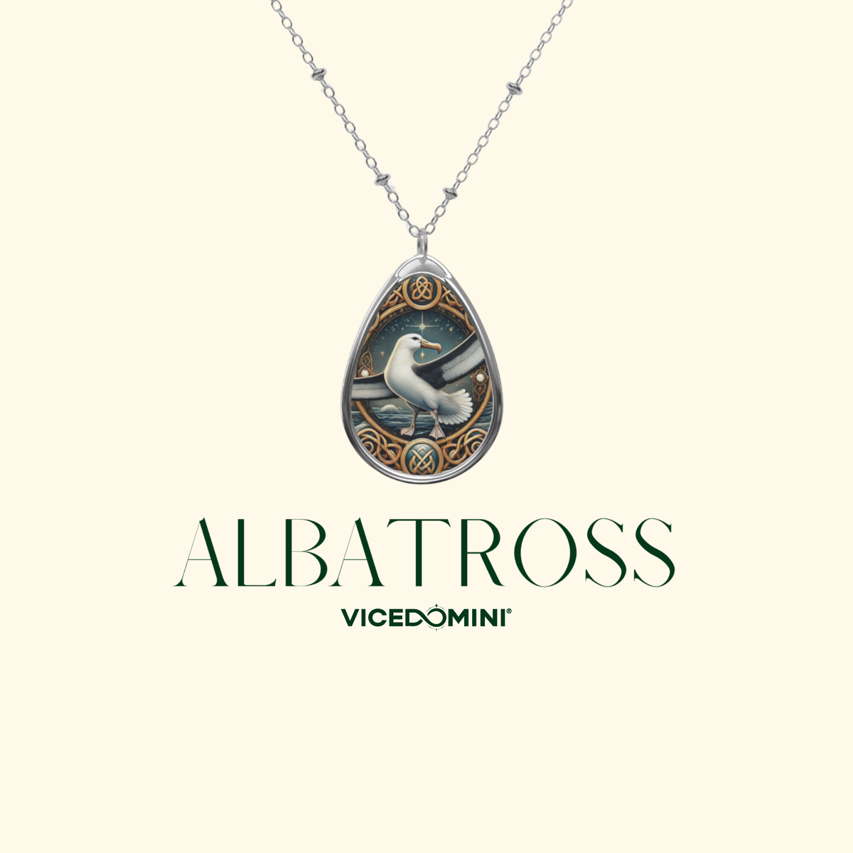 A teardrop-shaped pendant necklace on a silver chain, featuring an intricate illustration of an albatross in a circular frame with Celtic knotwork details. The pendant is displayed against a light cream background with the brand name 'ALBATROSS' and 'VICEDOMINI' printed below.
