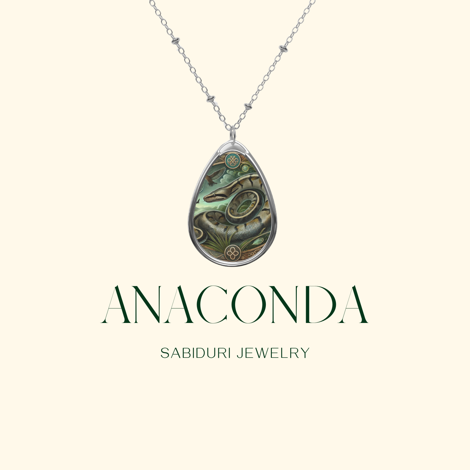 A delicate silver necklace with a teardrop-shaped pendant showcasing an anaconda in a jungle-themed design with intricate details. The pendant is displayed on a neutral background, with the text "ANACONDA" and "SABIDURI JEWELRY" elegantly positioned beneath.