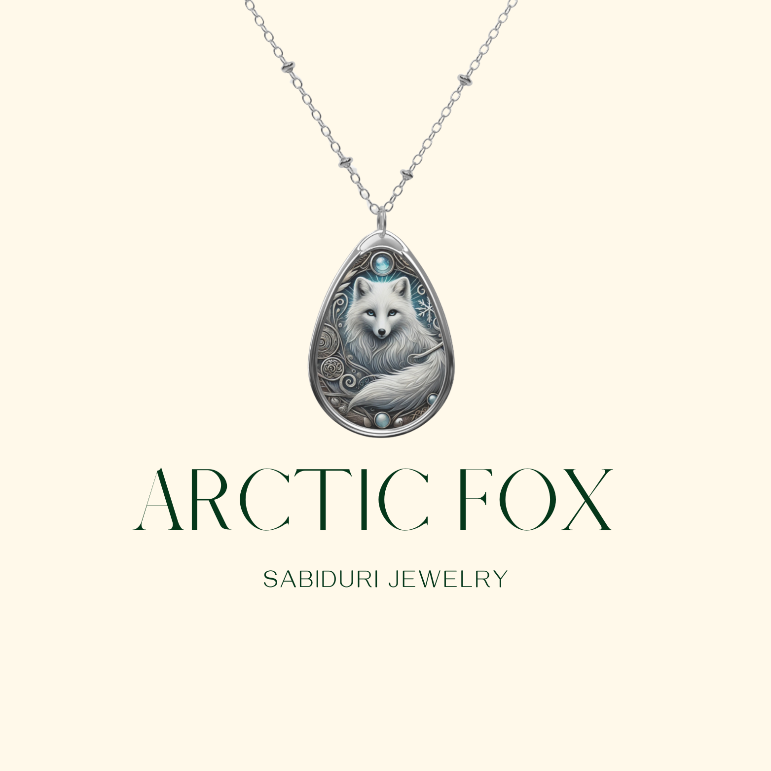 A delicate silver necklace with a teardrop-shaped pendant showcasing an Arctic fox surrounded by elegant, frost-inspired engravings. The pendant is displayed on a neutral background, with the text "ARCTIC FOX" and "SABIDURI JEWELRY" elegantly positioned beneath.