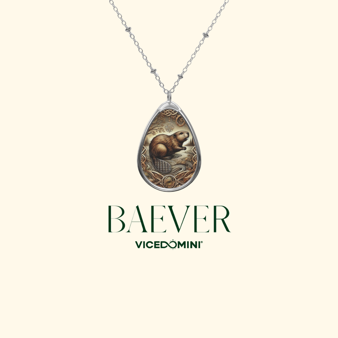 A teardrop-shaped pendant necklace featuring a detailed illustration of a beaver in a natural setting, framed by a silver-toned border and hanging from a delicate chain. The brand name 'BAEVER' and sub-brand 'VICEDOMINI' are displayed below on a solid cream background.
