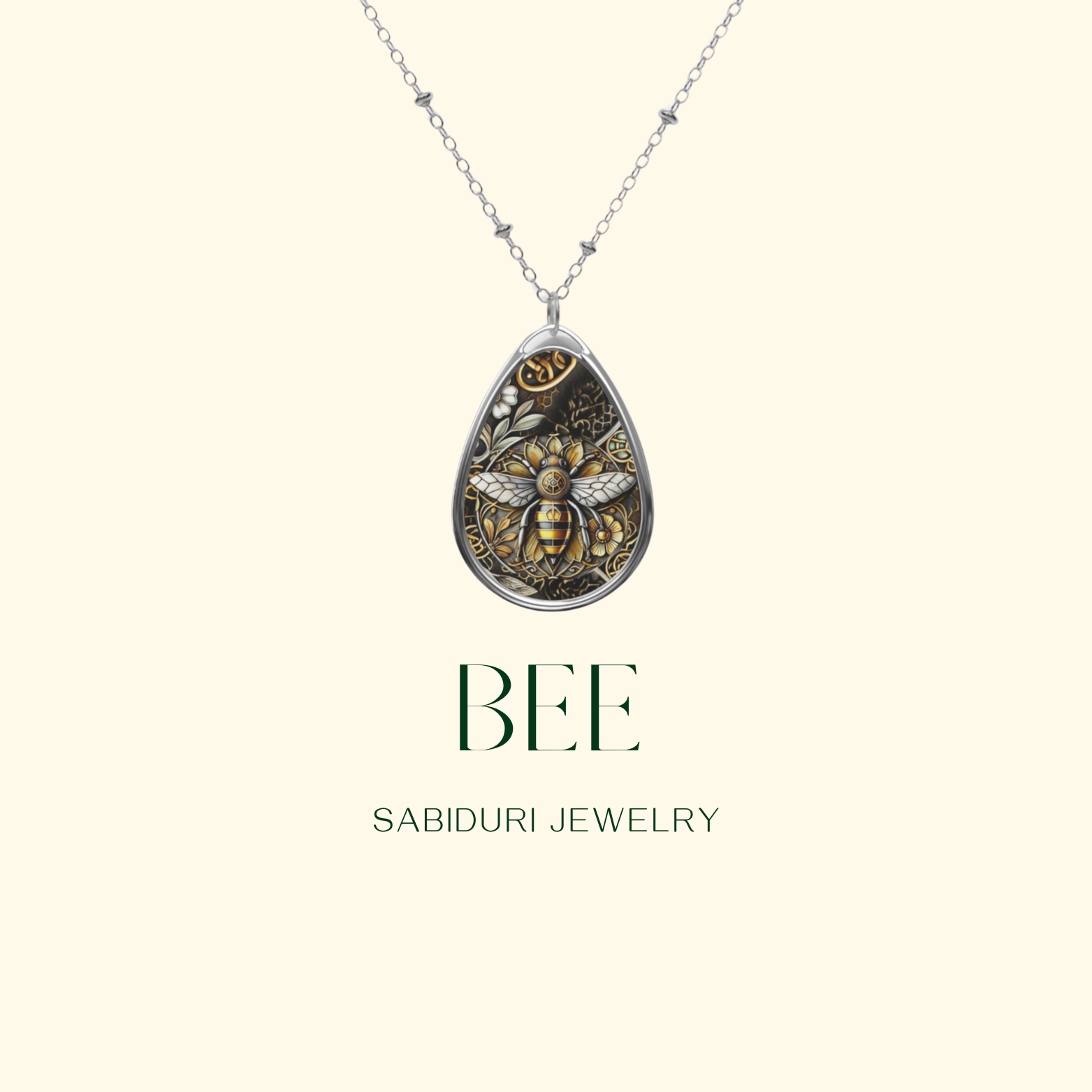 A close-up of the bee pendant with detailed gold and black artwork, displayed on a simple light background with the text "BEE" in bold green letters and "SABIDURI JEWELRY" beneath it.