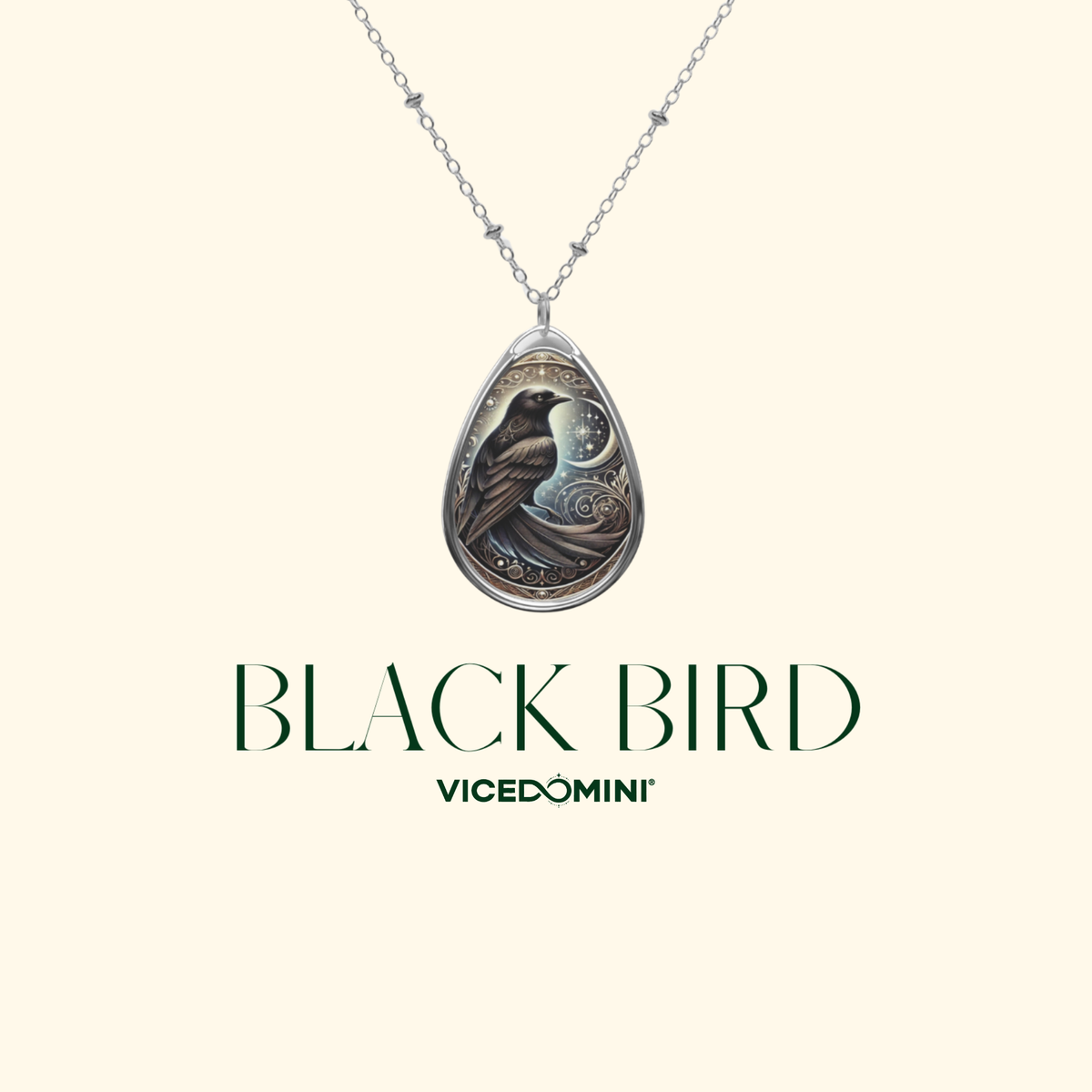 A minimalist product image of the Black Bird Spirit Animal Necklace on a soft cream background, featuring the pendant suspended from a silver chain with "Black Bird" and "VICEDOMINI" written below.