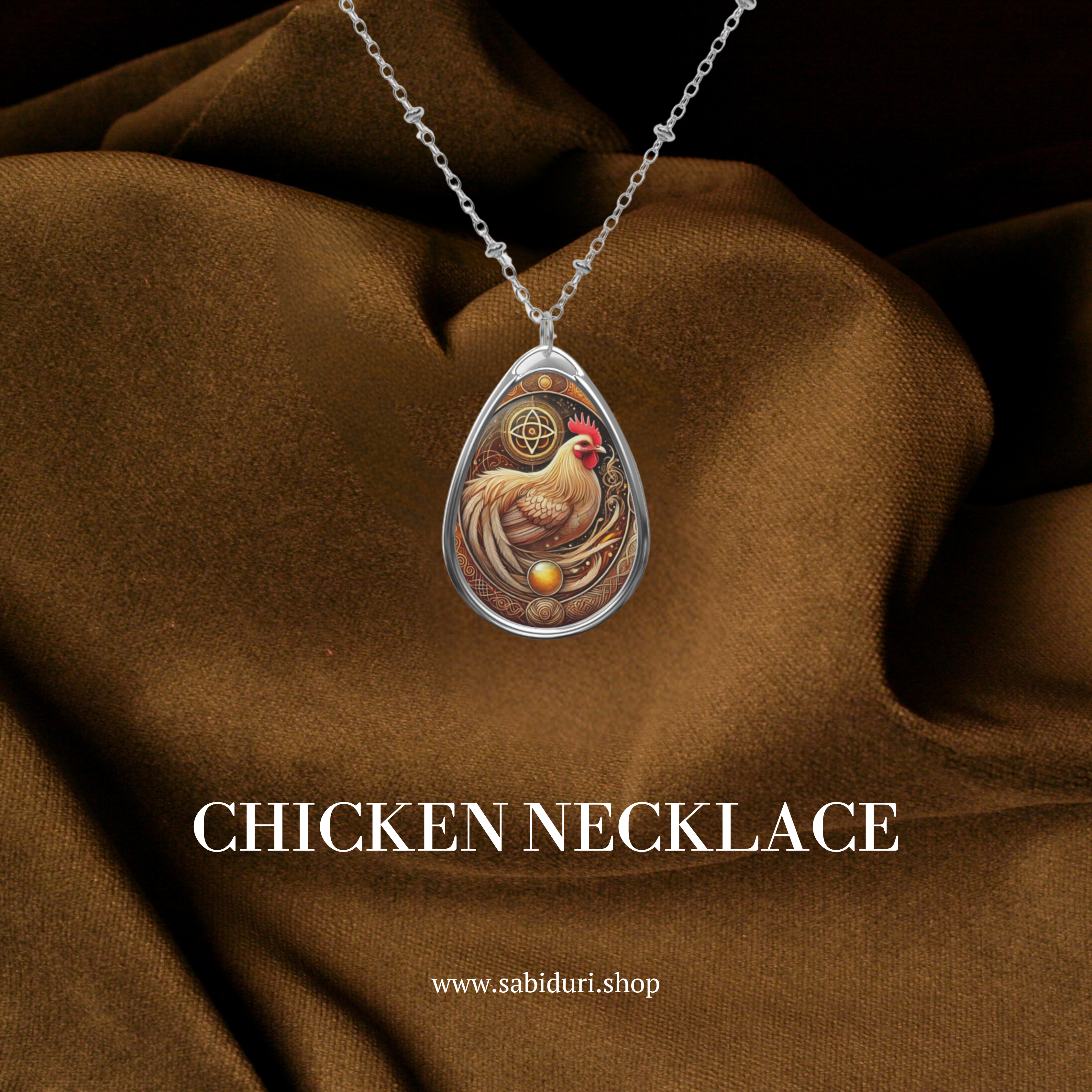 A close-up of the cormorant necklace displayed on rich brown fabric. The pendant showcases a black cormorant against a golden background with swirling waves and celestial details. The text "CORMORANT NECKLACE" and "www.sabiduri.shop" is displayed, enhancing the promotional appeal.