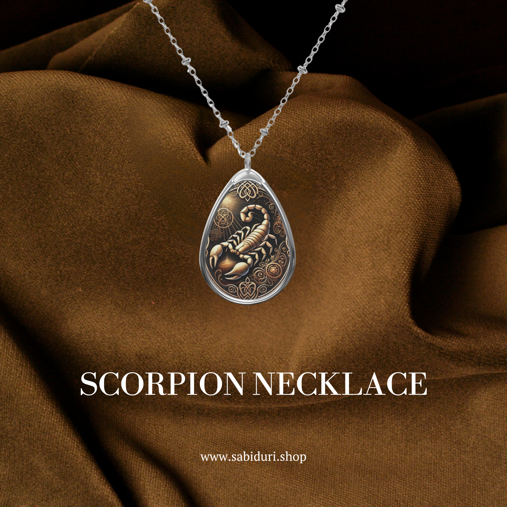 A silver scorpion pendant necklace with intricate Celtic-inspired engravings in gold and black tones. The pendant is displayed against a luxurious brown fabric background, with the text "SCORPION NECKLACE" and the website "www.sabiduri.shop" below.