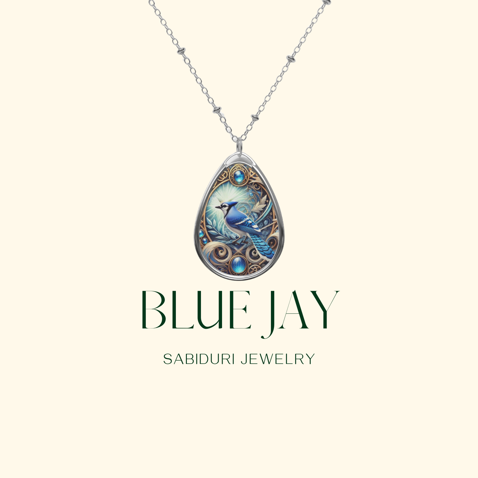 A minimalist image of a silver teardrop necklace pendant featuring a blue jay with ornate design details and blue gemstones, set against a pale background. The text reads "BLUE JAY SABIDURI JEWELRY."