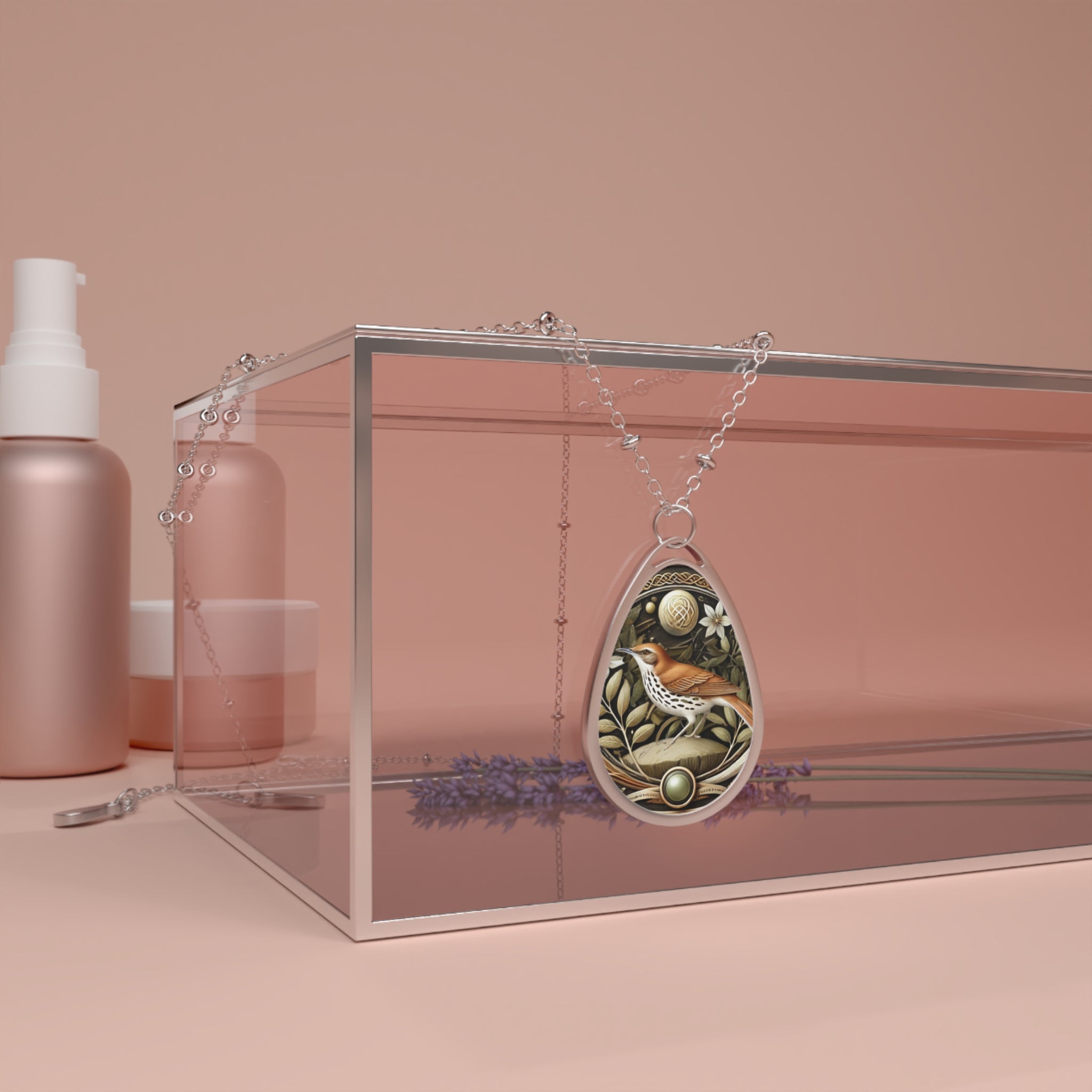 A Brown Thrasher spirit animal necklace displayed elegantly on a glass box with a soft pink backdrop, showcasing intricate brown and white bird artwork surrounded by natural motifs and a polished metal finish.