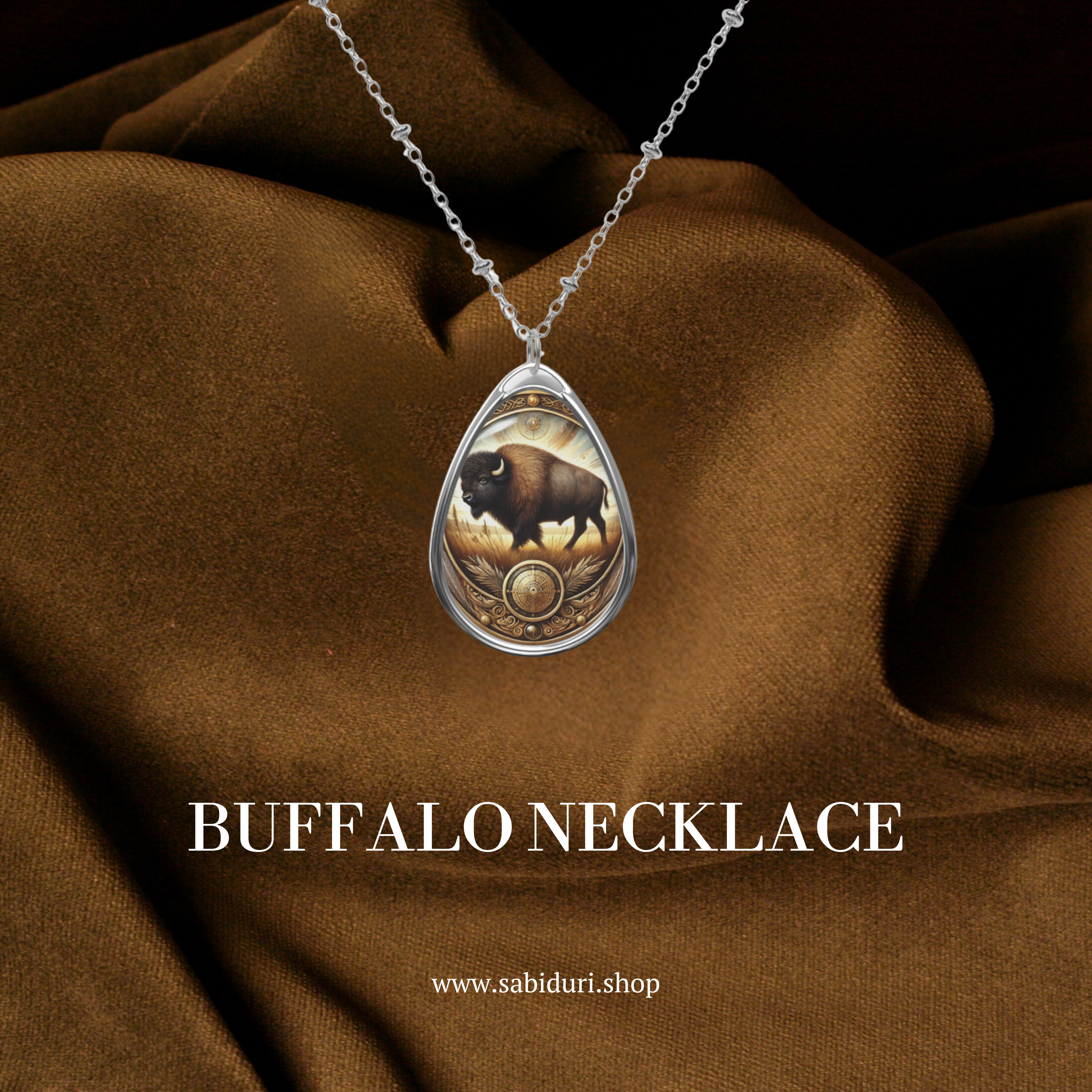 A close-up of a buffalo spirit animal necklace with a golden glow, set against a rich brown fabric backdrop. The pendant showcases a buffalo in a field, framed by intricate golden patterns.