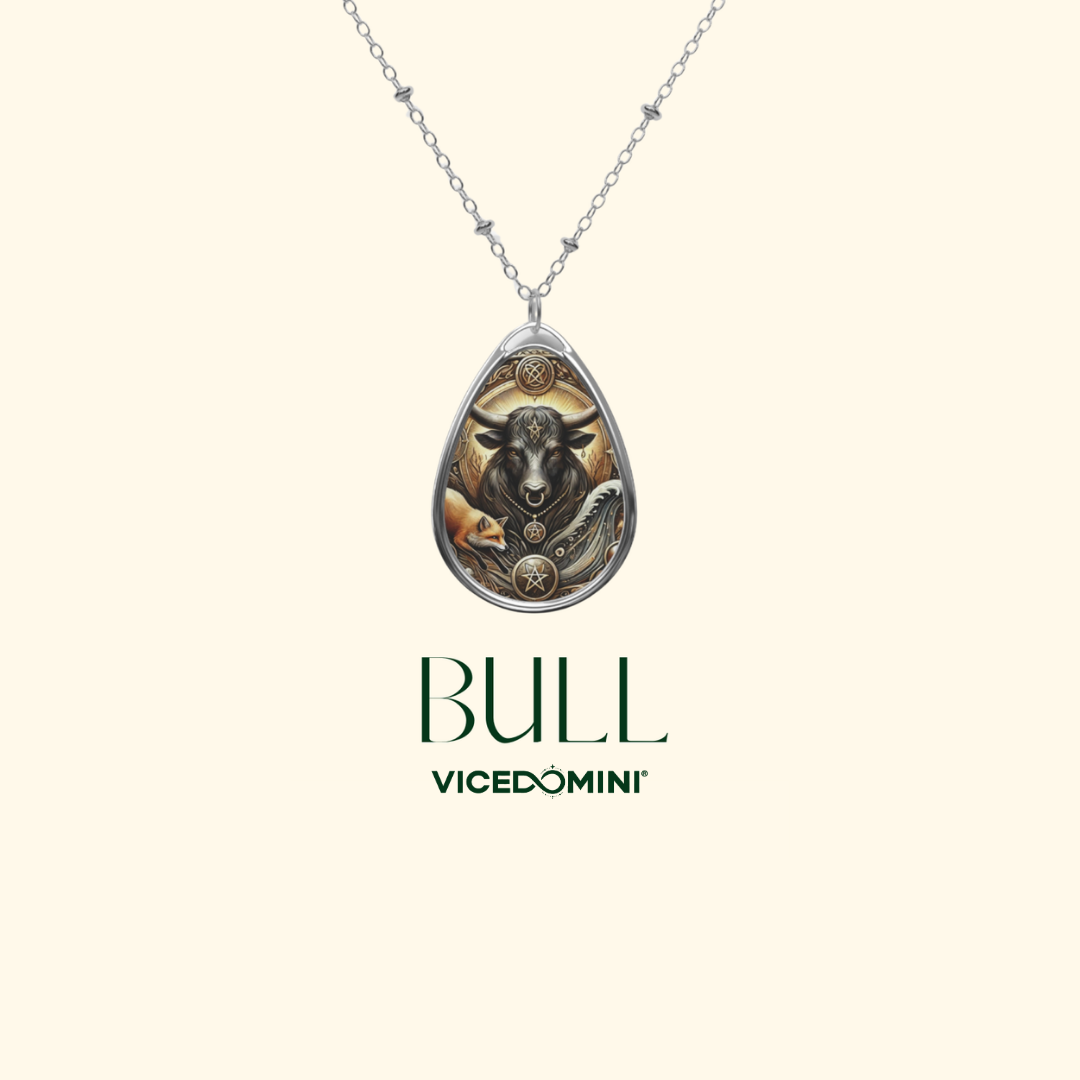 A silver teardrop pendant necklace featuring an artistic bull illustration with gold and brown tones, shown on a light cream background with the brand name 'BULL VICEDOMINI' printed below.