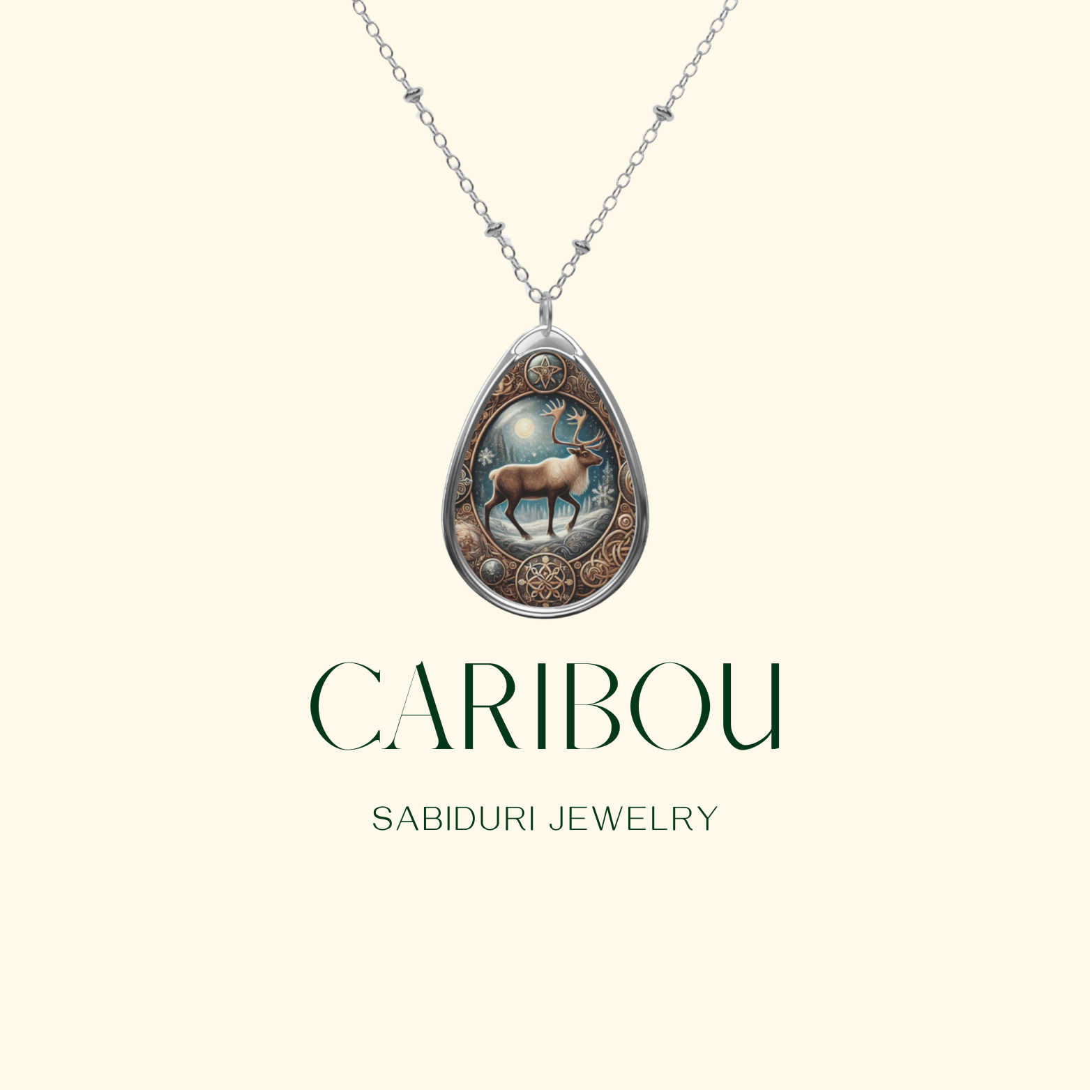 A digitally designed Caribou Necklace displayed against a cream background. The pendant features a caribou under the moonlight, framed by an ornate border, with the words "CARIBOU" and "SABIDURI JEWELRY" in an elegant font.