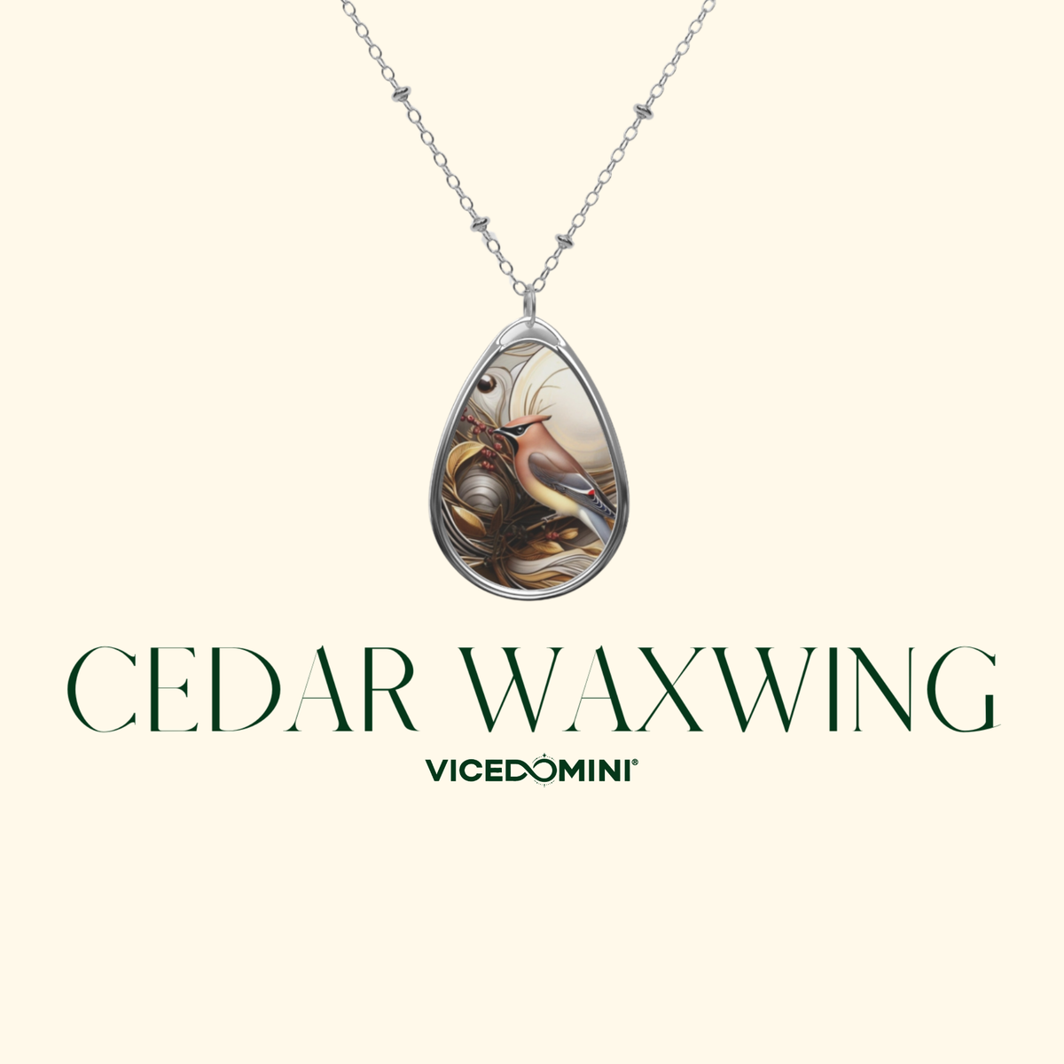 A teardrop-shaped pendant necklace featuring a detailed illustration of a cedar waxwing bird, suspended from a silver chain against a light cream background. The text 'CEDAR WAXWING' and the brand 'VICEDOMINI' are displayed below.