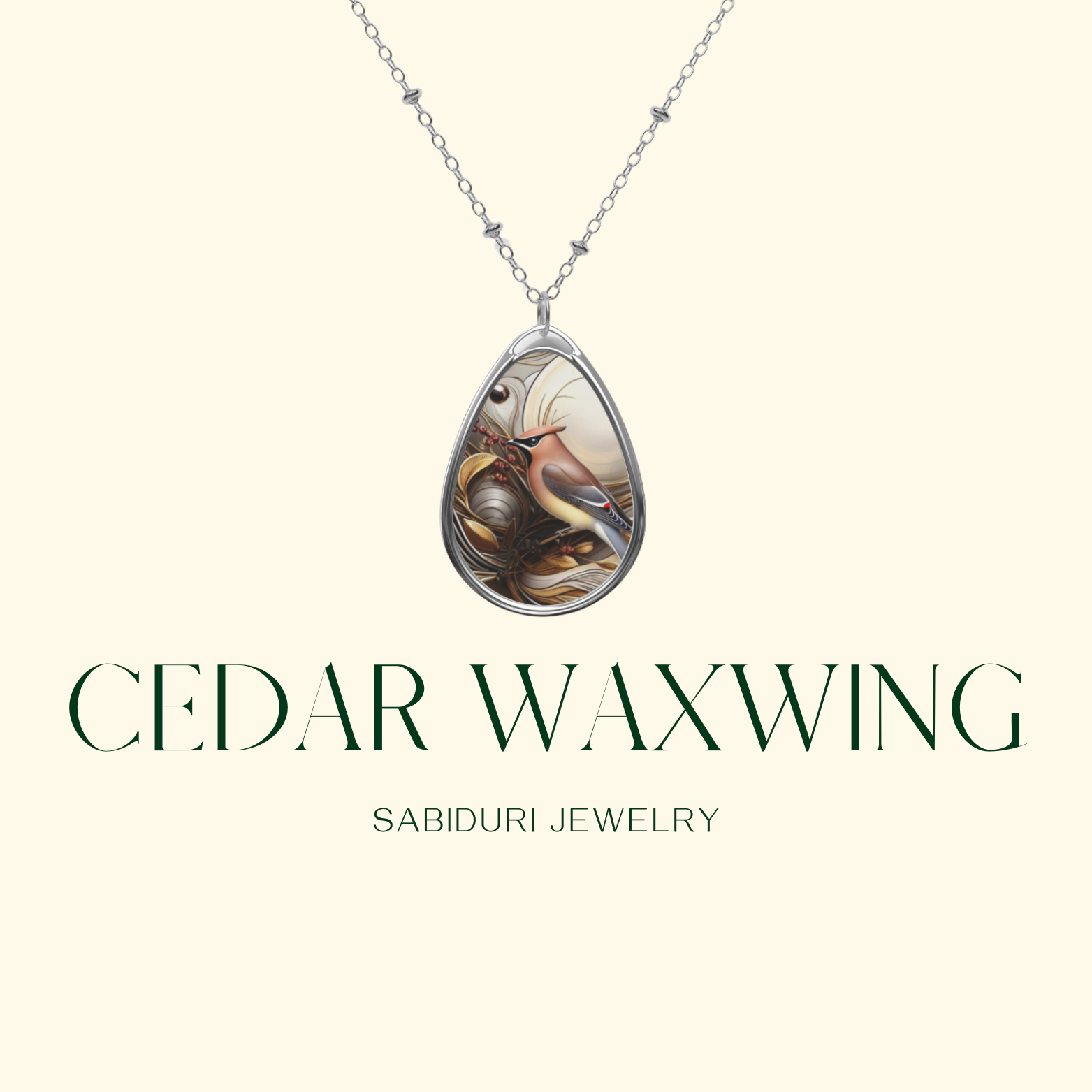 A close-up of a silver teardrop pendant with an artistic depiction of a cedar waxwing bird, its feathers blending with organic, ornamental designs. The necklace is displayed against a clean, neutral background with "Cedar Waxwing" and "Sabiduri Jewelry" written in sophisticated typography.