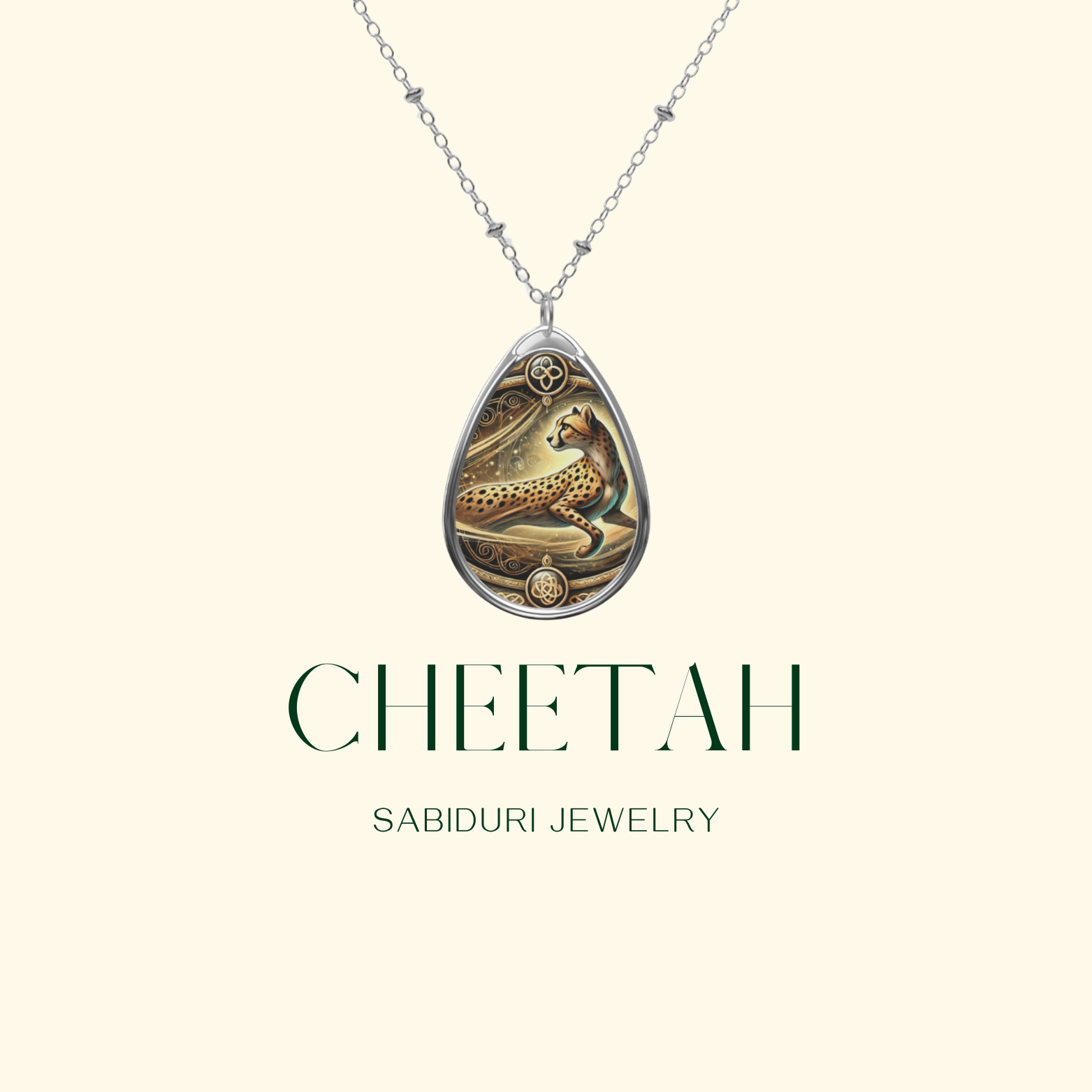 A refined teardrop-shaped cheetah pendant with intricate gold and black details, suspended on a silver chain. The necklace is centered against a soft beige background, emphasizing its sophisticated design. "Cheetah - Sabiduri Jewelry" is written in a modern serif font below the pendant.