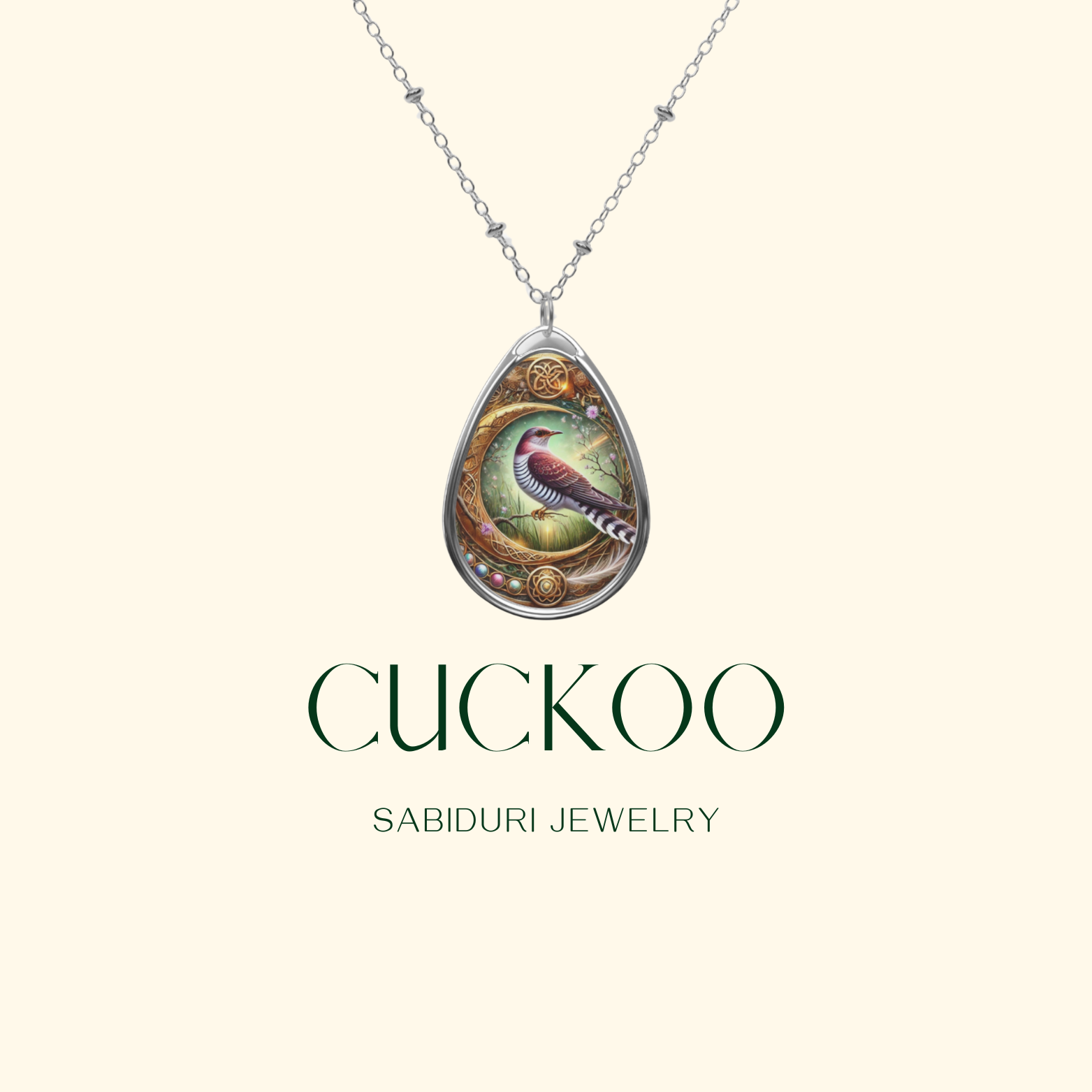 A digital product display of a silver cuckoo bird necklace with an ornate frame, set against a light cream background with the text "CUCKOO" and "SABIDURI JEWELRY."