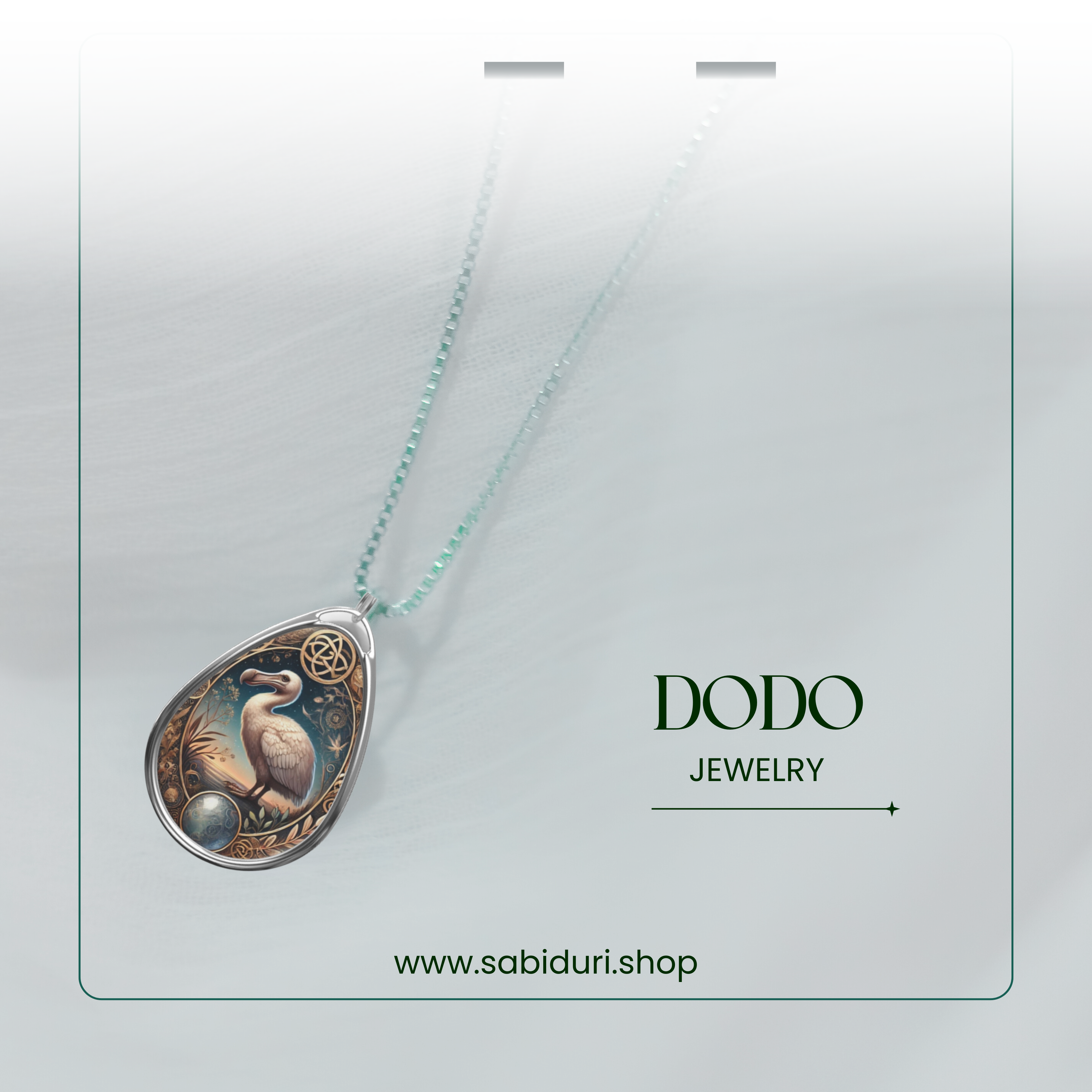 A softly blurred, minimalistic image showcasing the dodo spirit animal pendant hanging from a delicate beaded silver chain. The branding "DODO JEWELRY" and "www.sabiduri.shop" are subtly placed to the right of the pendant.