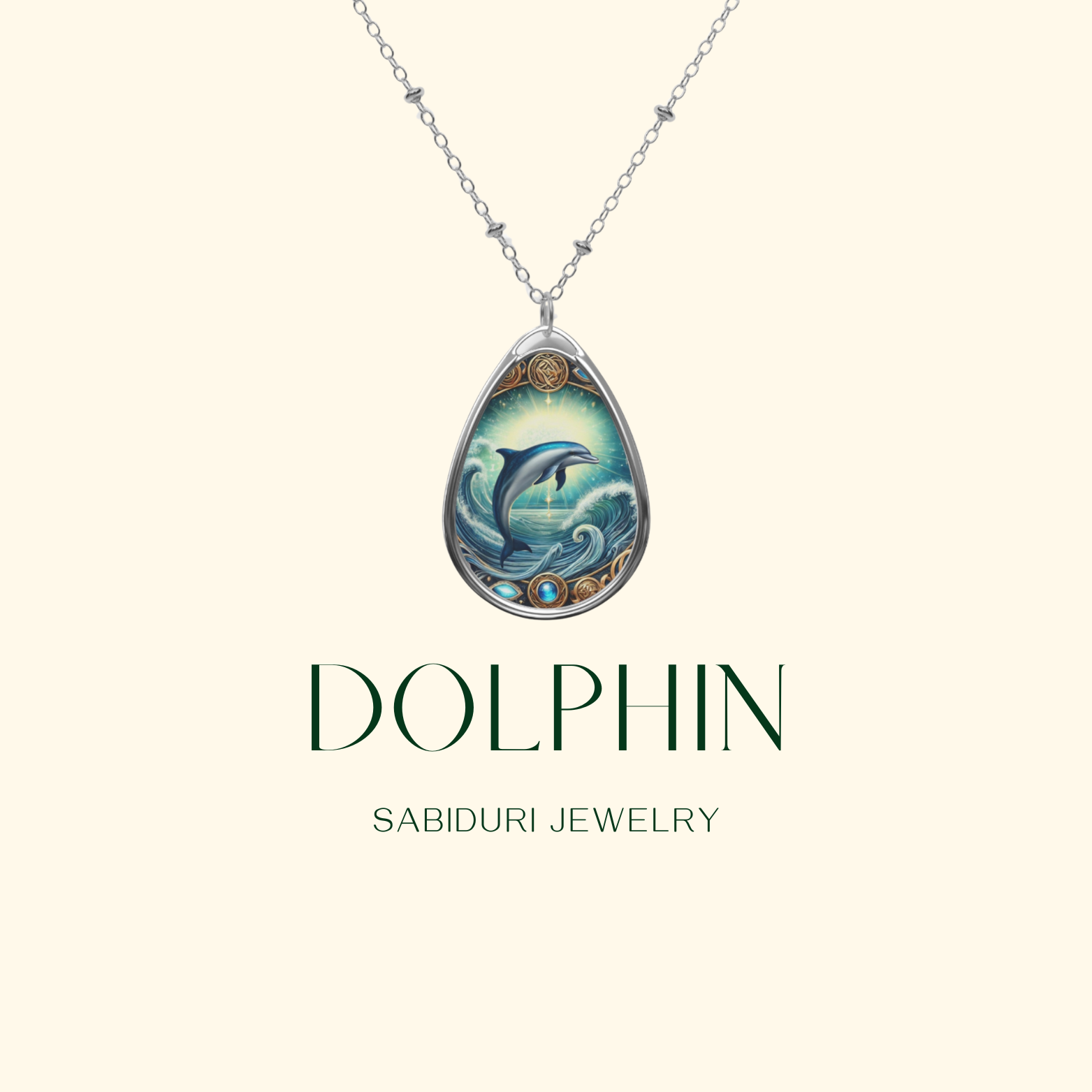 A minimalistic presentation of the Dolphin necklace on a light beige background. The pendant hangs from a delicate silver chain, featuring a blue dolphin within a detailed golden frame. The text "DOLPHIN" and "SABIDURI JEWELRY" appear in elegant typography.