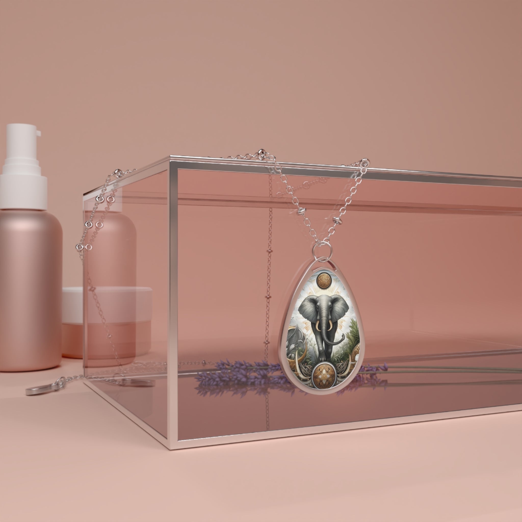 A silver necklace featuring an elephant pendant draped over a clear box with lavender and cosmetics in the background, set against a soft pink backdrop. The pendant showcases a majestic elephant in a natural setting with intricate celestial and earth-inspired motifs, symbolizing strength and wisdom.