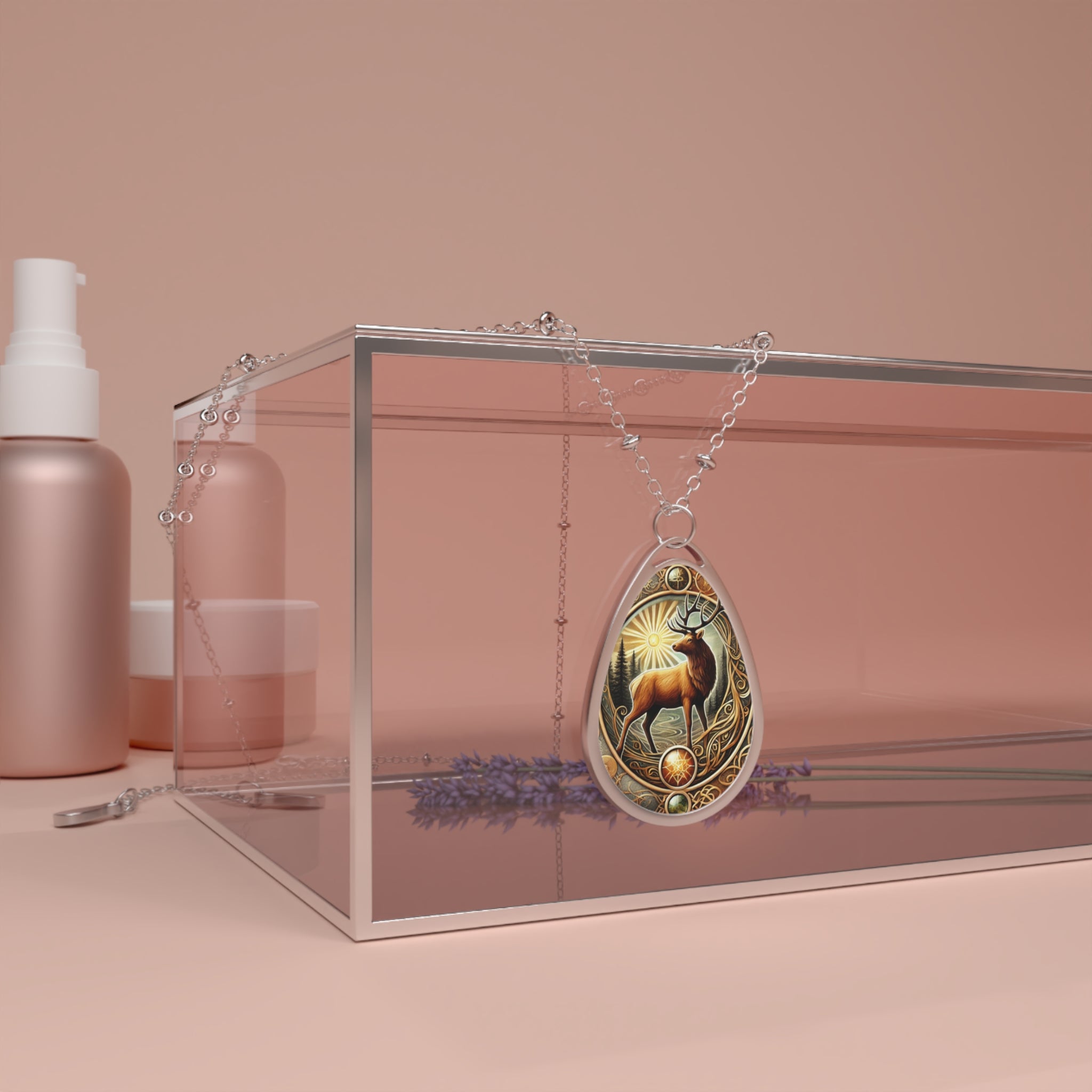 A teardrop-shaped pendant necklace featuring an intricately designed elk standing tall in a sunlit forest scene. The pendant is adorned with golden filigree and gemstone accents, suspended on a delicate silver chain. The background showcases a minimalist, peach-toned aesthetic with a glass display box and lavender sprigs.