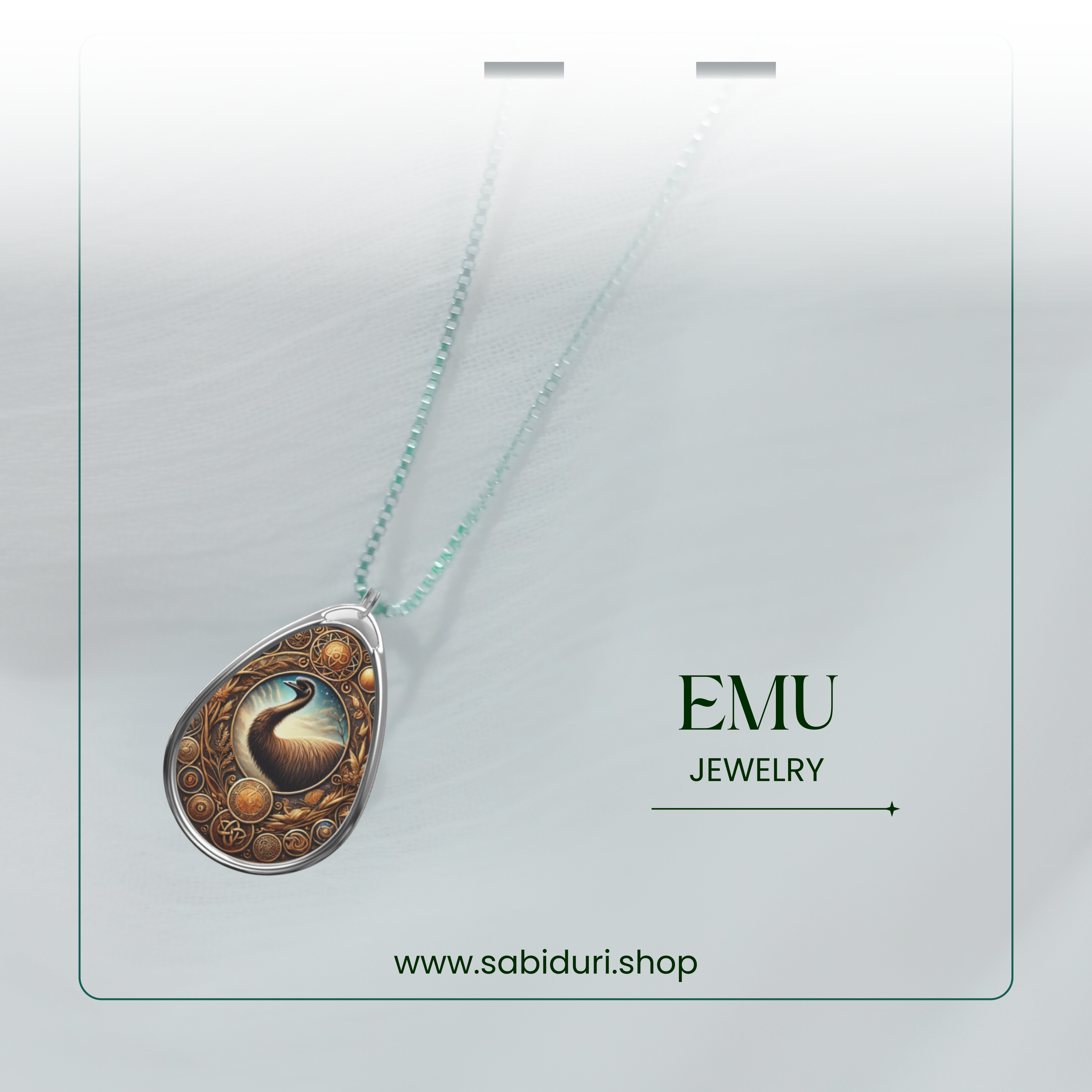 A silver chain necklace featuring a teardrop-shaped pendant with an intricately designed emu set against a cosmic-inspired background. The image is framed with a delicate green border, adding a refined touch to the jewelry’s presentation.