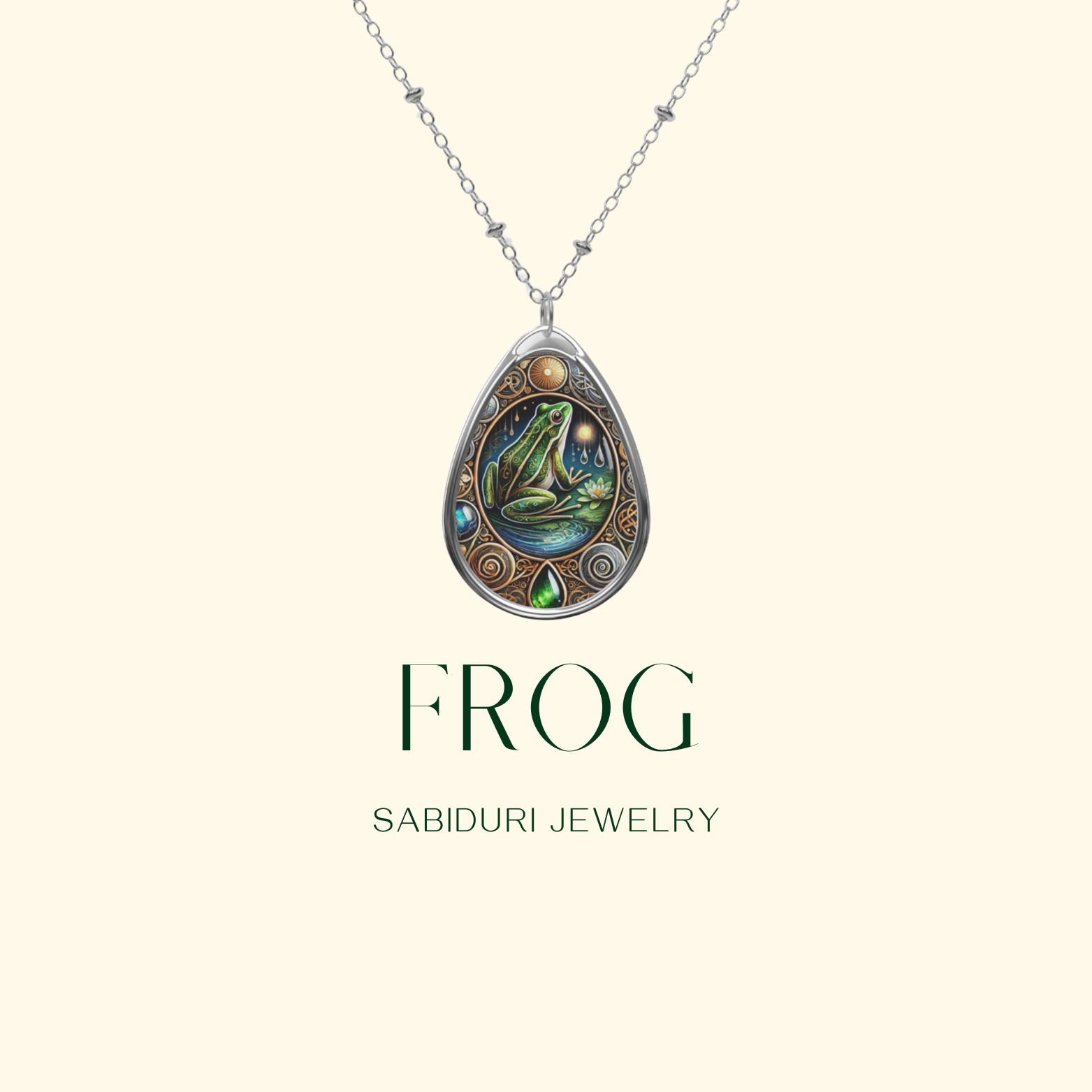 A minimalist promotional image showcasing the frog pendant against a clean beige background. The text "FROG" and "SABIDURI JEWELRY" is displayed below, emphasizing the nature-inspired design.