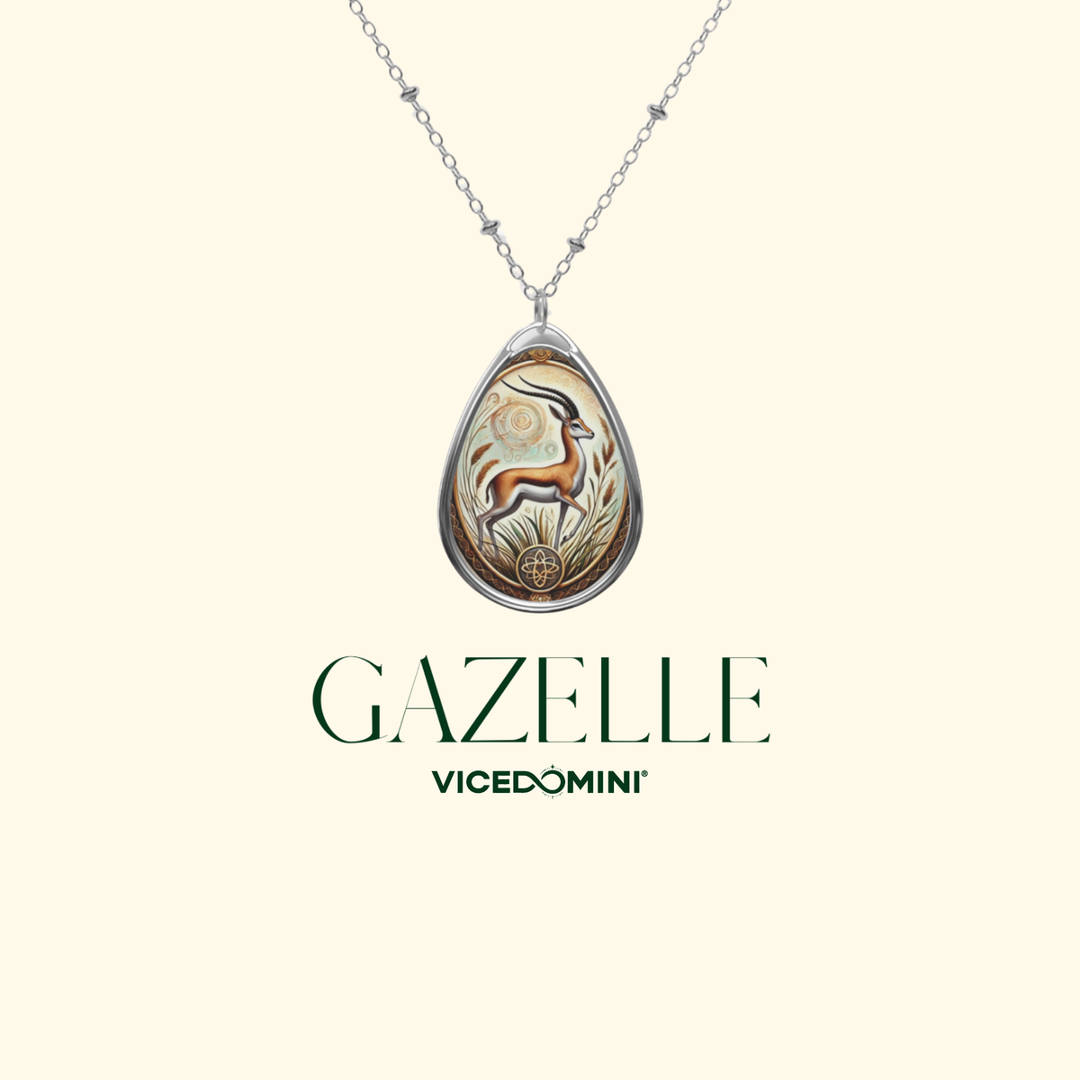 A Vicedomini Gazelle pendant necklace featuring a teardrop-shaped silver pendant with an intricate giraffe illustration in gold, brown, and white, suspended from a delicate silver chain on a light cream background with the brand name 'GAZELLE VICEDOMINI' printed below.