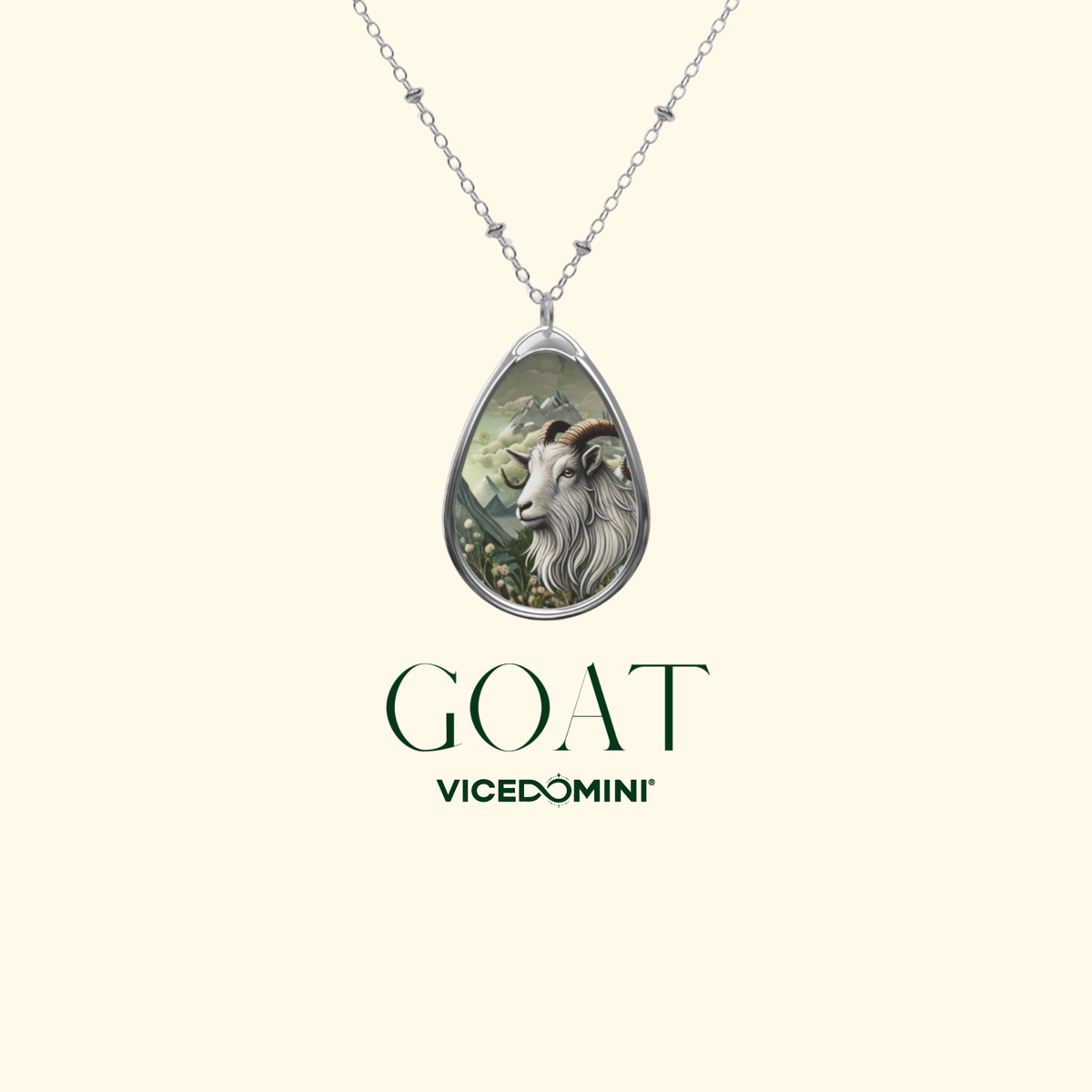A silver teardrop pendant necklace featuring an illustration of a goat, shown on a light cream background with the text 'GOAT VICEDOMINI' below.