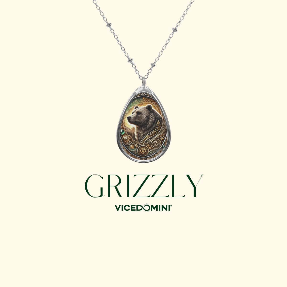 A silver teardrop pendant necklace featuring an engraved grizzly bear illustration, shown on a light cream background with the brand name 'GRIZZLY' and sub-brand 'VICEDOMINI' printed below.