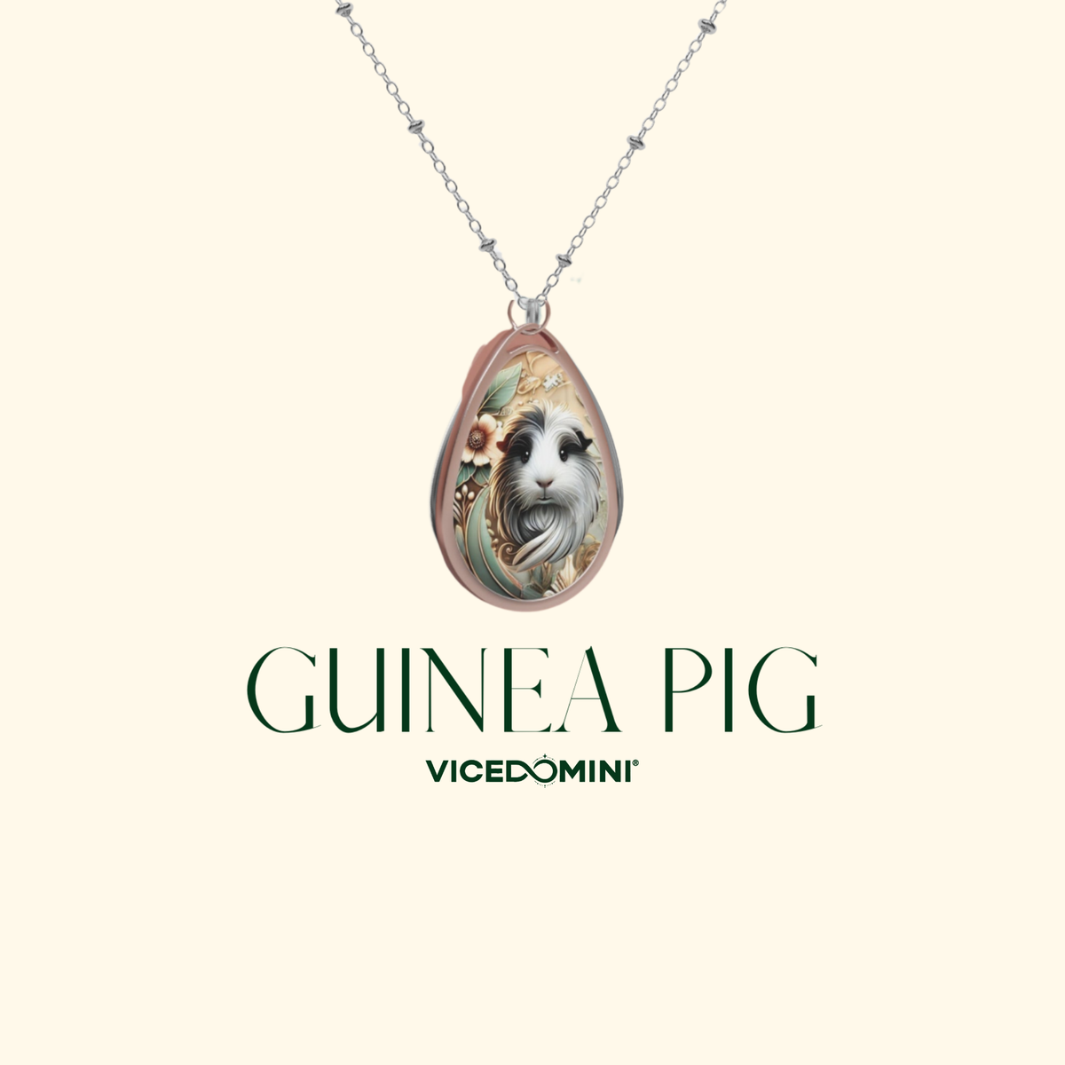 A teardrop-shaped pendant necklace featuring a detailed illustration of a guinea pig, suspended from a delicate silver chain. The pendant is displayed against a solid cream background with the text 'GUINEA PIG' and the brand name 'VICEDOMINI' printed below.