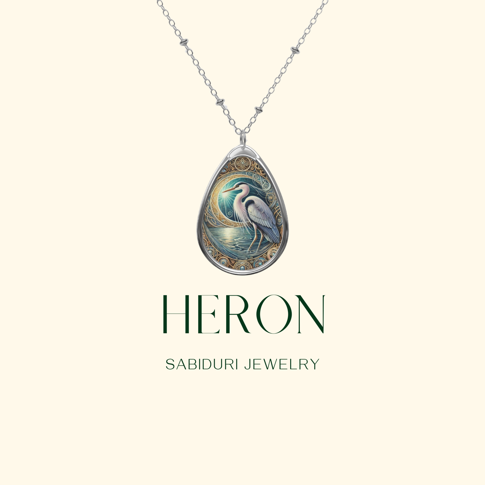  A silver teardrop-shaped pendant featuring an intricately detailed heron standing by a moonlit water scene, adorned with swirling gold embellishments. The necklace is displayed against a soft cream background with "HERON" and "SABIDURI JEWELRY" written below.