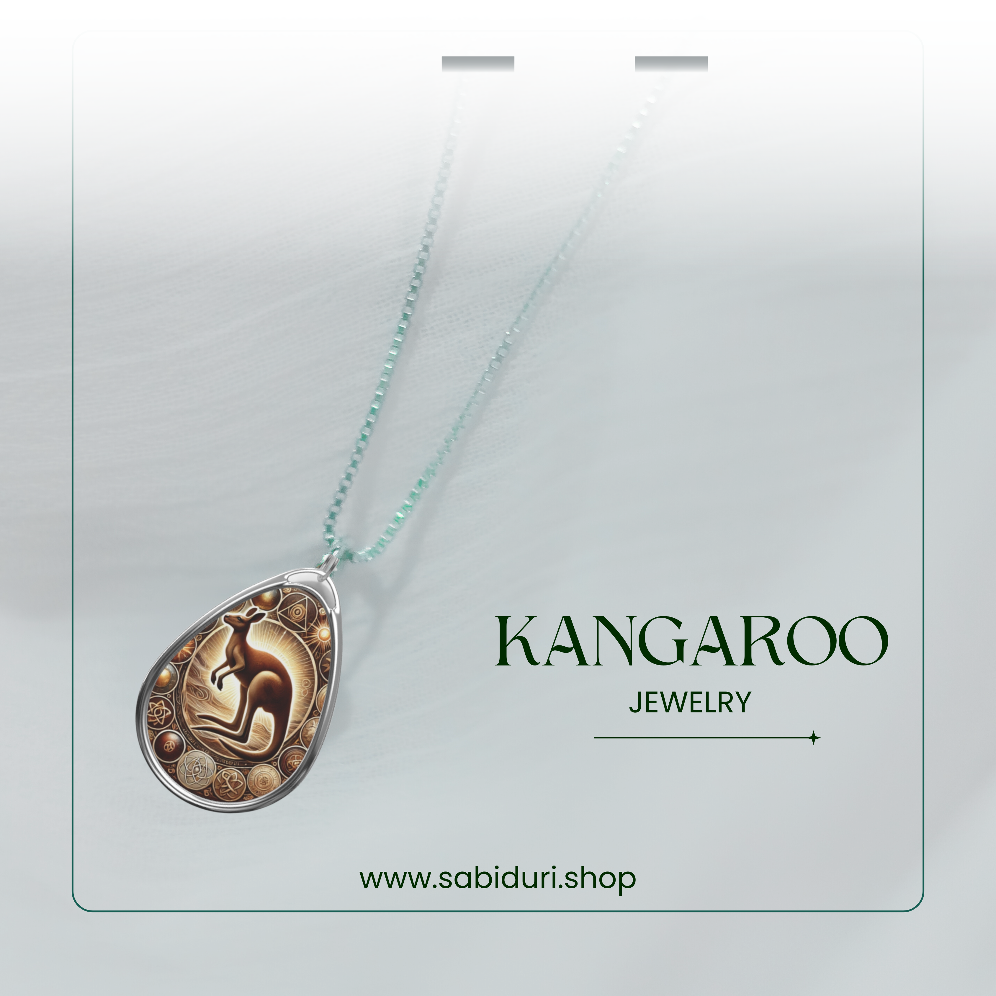 A close-up shot of a kangaroo pendant necklace suspended against a soft, blurred white background. The detailed pendant features a stylized kangaroo in a golden and earthy-toned setting, with intricate circular patterns. "Kangaroo Jewelry" and "www.sabiduri.shop" are displayed at the bottom.