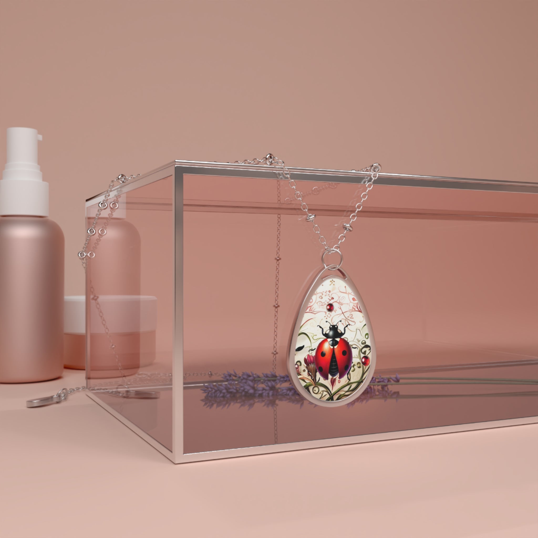 A silver necklace with a teardrop-shaped pendant featuring a red ladybug on a nature-inspired background, elegantly draped over a transparent box with rose gold-colored cosmetic bottles in the background, creating a soft and sophisticated aesthetic.