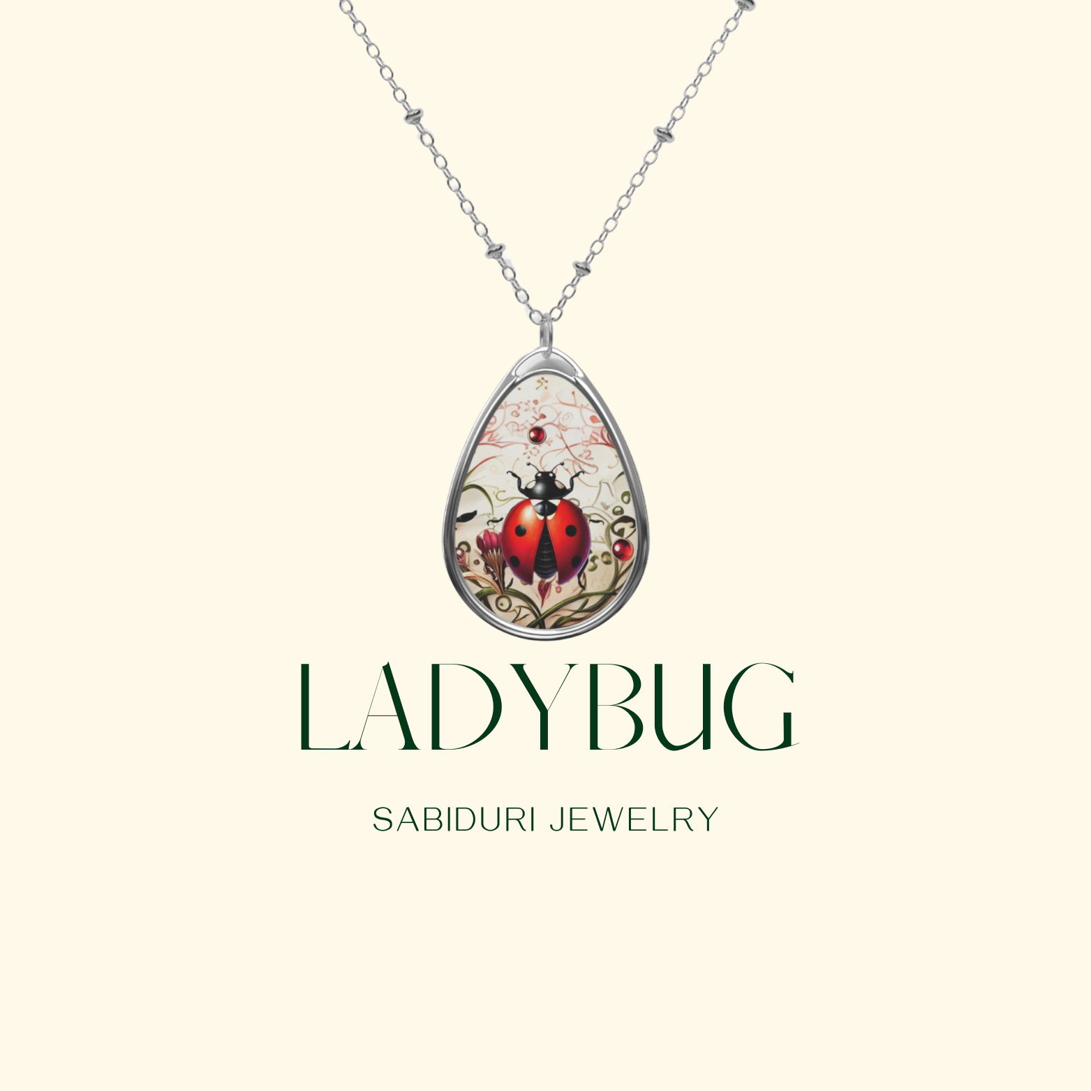 A silver necklace with a teardrop-shaped pendant featuring a detailed illustration of a red ladybug on a delicate, nature-inspired background. The pendant is displayed against a light cream background with the text "LADYBUG SABIDURI JEWELRY" written below.