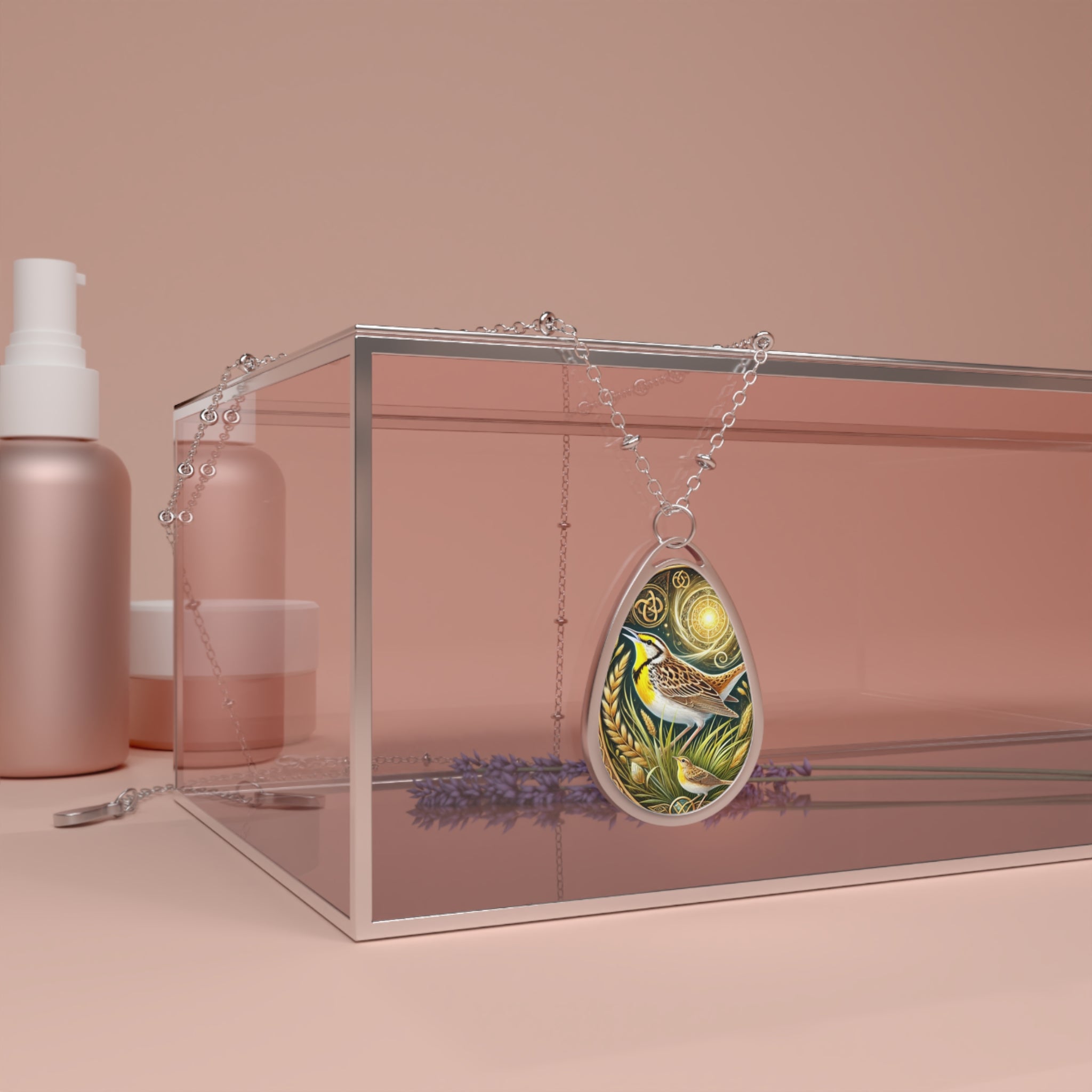 The meadowlark necklace draped over a glass jewelry box with a blush pink hue. The pendant's golden and brown hues contrast beautifully with the soft pastels, emphasizing the detailed nature-inspired artwork of the bird and wheat.