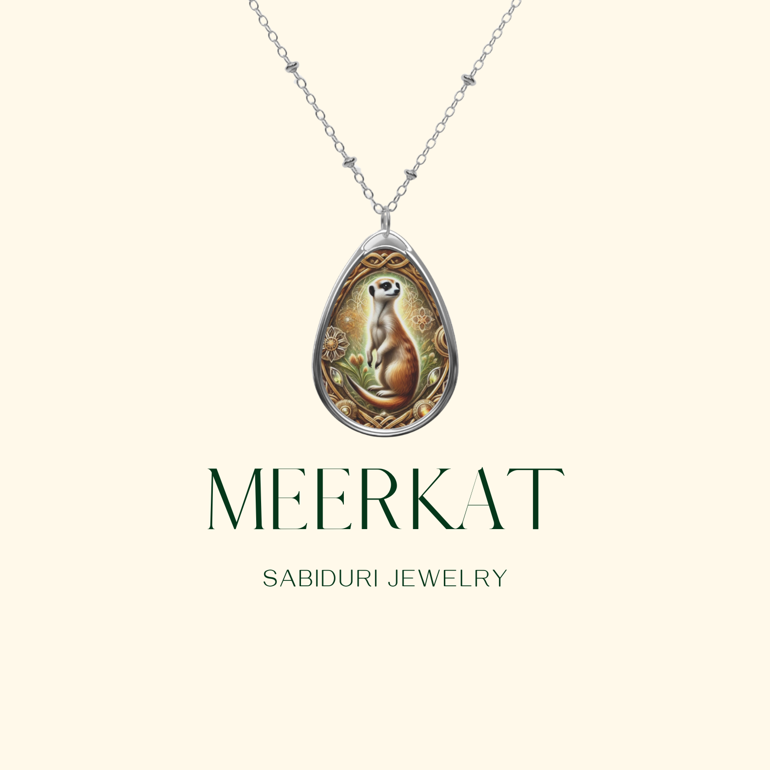 A silver teardrop-shaped pendant necklace featuring an intricate illustration of a meerkat standing alert, surrounded by ornate golden patterns and floral details. The text "MEERKAT" and "SABIDURI JEWELRY" is displayed beneath the pendant on a neutral background.