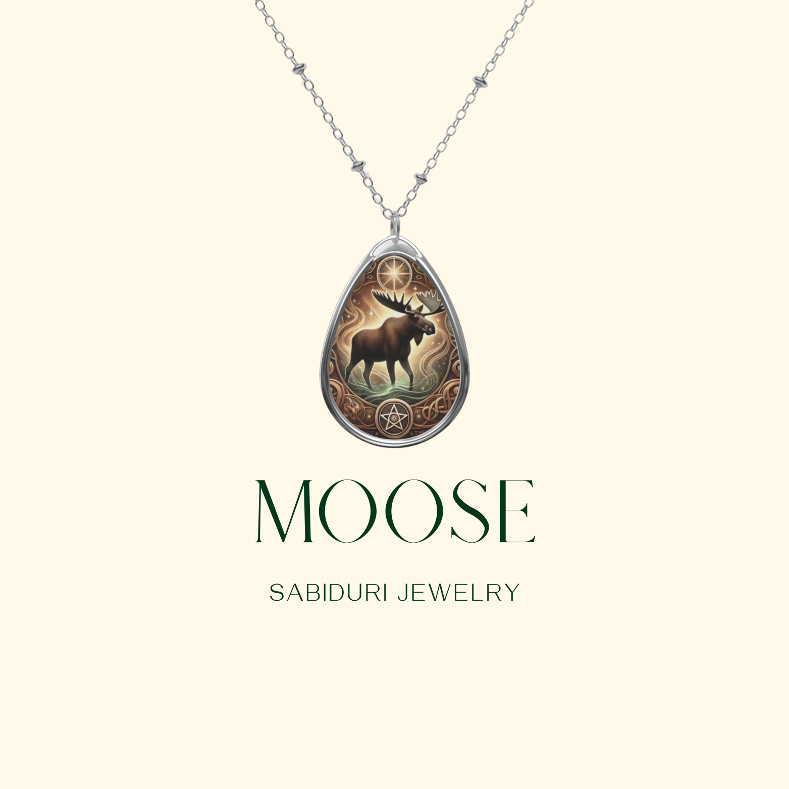 A close-up of a moose pendant on a thin silver chain against a minimalist cream-colored background. The pendant showcases a majestic moose framed by an ornate design, with "MOOSE" and "SABIDURI JEWELRY" in elegant typography.